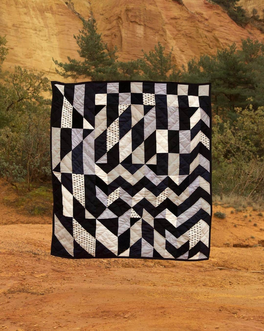 アーペーセーのインスタグラム：「A.P.C. Quilts Round 18 ⠀ ⠀ For the creation of round 18 of A.P.C. quilts, Jessica Ogden started by making a series of small paintings inspired by a photo of Jean and herself, taken when they received a collection ordered by Anthropologie several years ago.⠀ ⠀ The photo gave her the idea of mixing different patchwork techniques, like those used for the order. To move away from the usual restraints of quilt creation, Jessica drew inspiration from her own paintings. Then, this work was adapted to the needs of the project (limited amount of fabrics). This added an additional layer to the creative process.⠀ ⠀ Round 18 is paradoxical in that it injects poetic randomness into an “imposed figure.”⠀ — Jean Touitou⠀ ⠀ The campaign photos were shot in the Lubéron region in France by Alfredo Piola.⠀ ⠀ Available in stores and at apc.fr⠀ ⠀ #APC #APCQuilts #Round18 #APCFW20 #Quilts #StepbyStep ⠀」
