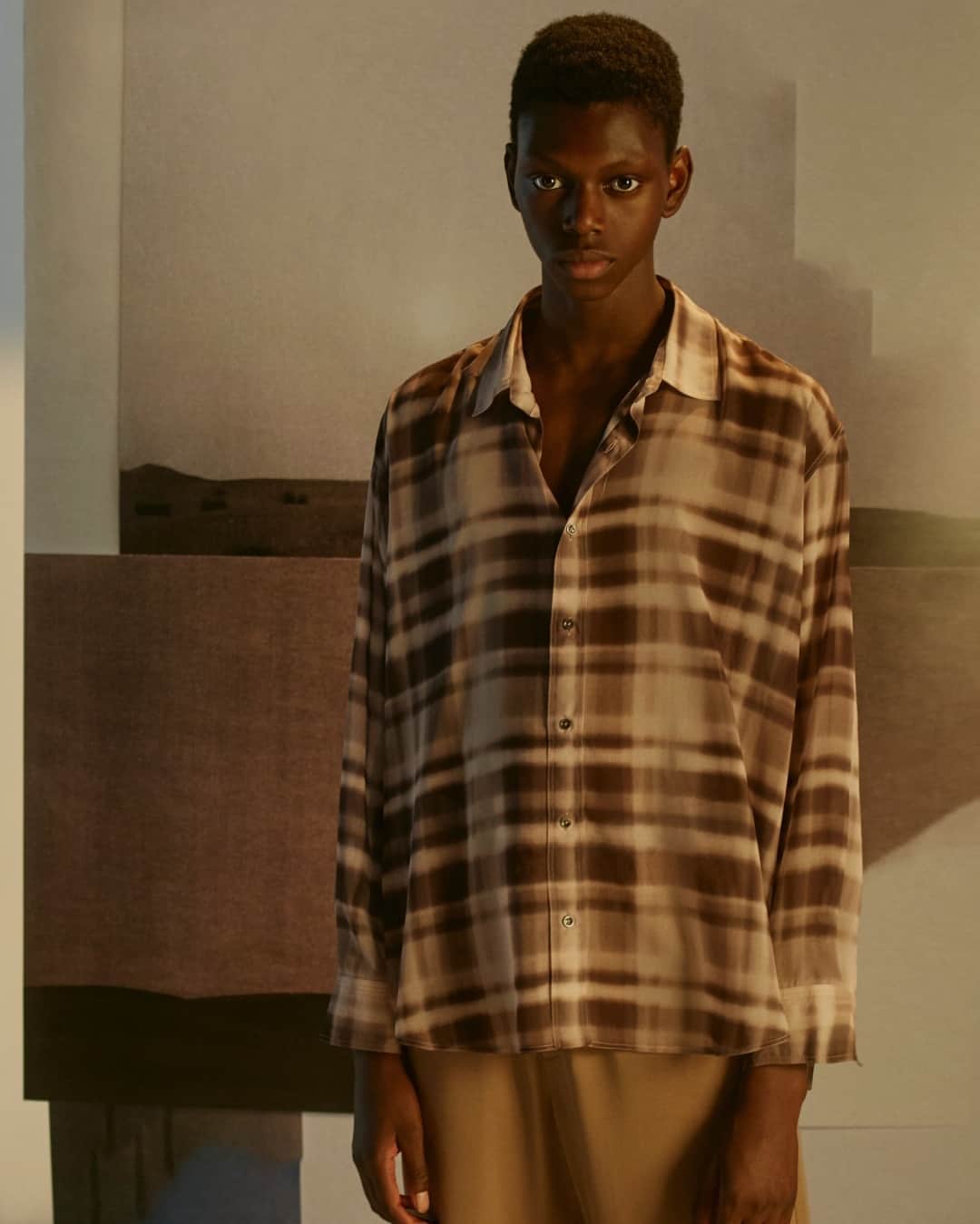 カシミ オムのインスタグラム：「The dad shirt in frosted peach check print - reminiscent of a blurred urban landscape with storied buildings enveloped in fog - act as the metaphorical backdrop for Qasimi’s urban nomad and his wanderings.  #qasimi #qasimidesign #garments」