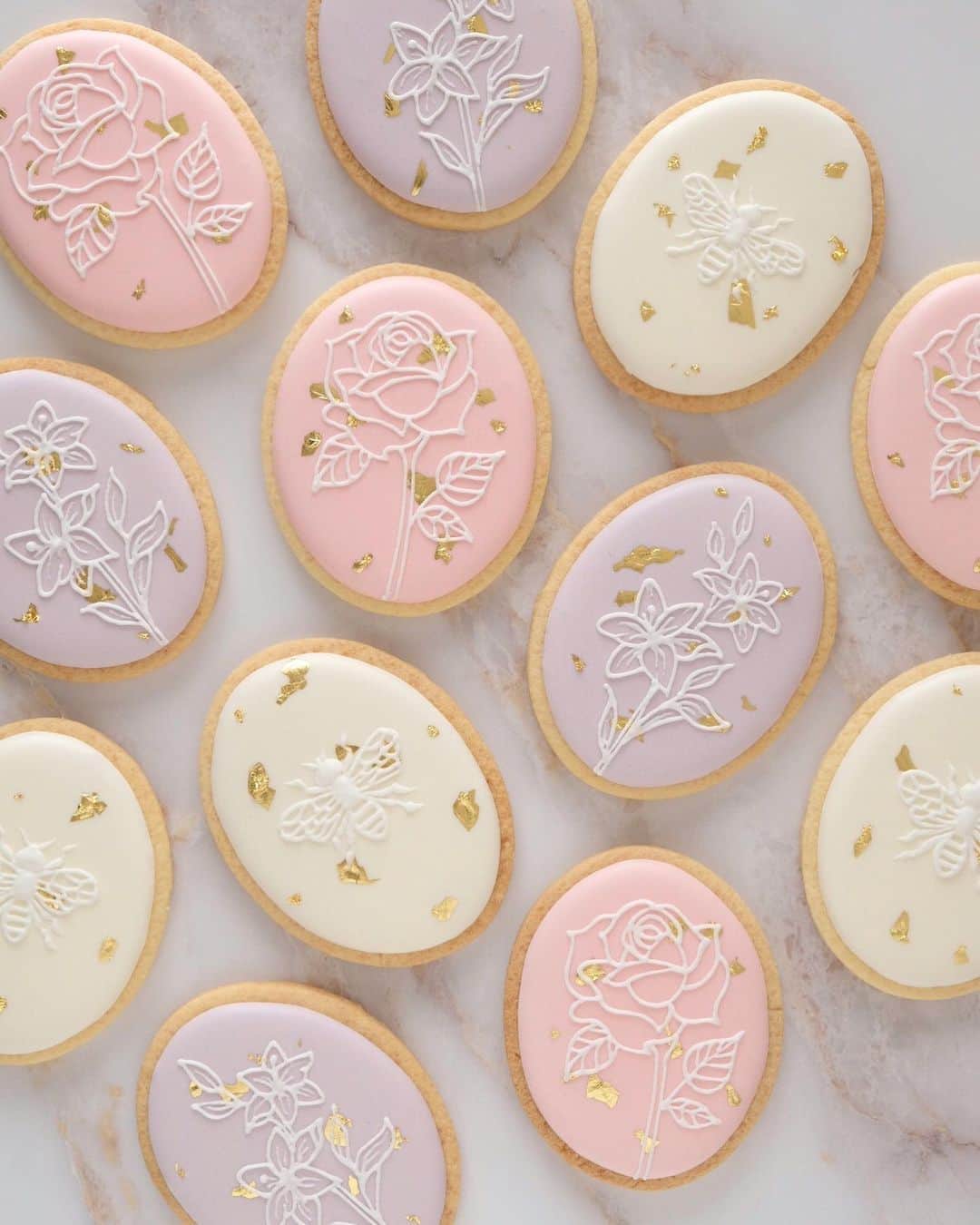 のインスタグラム：「Simple, Elegant, Romantic 🌸﻿ Oval cookies with gold foil.﻿ ﻿ 金箔を使った涼しげなオーバルクッキー。﻿ 薔薇と百合と蜂🐝🤍﻿ ﻿ #artofkunika」