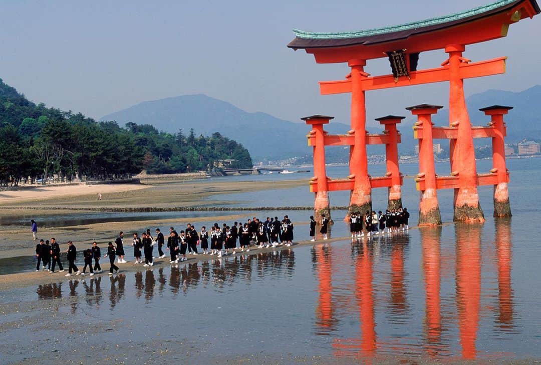 Michael Yamashitaさんのインスタグラム写真 - (Michael YamashitaInstagram)「Itsukushima Shrine is one of the most significant Shinto shrines in Japan and the only shrine in the world seemingly built on top of water. The name 'Itsukushima' literally means 'island of worship', and from ancient times the island itself was worshipped as a god. From its beginnings, the Itsukushima Shrine drew fishermen and tradesmen who sailed the Seto Inland Sea. Visitors today still pray for the safety of those who ply the sea.    The view of Itsukushima Shrine and its distinctive red O-torii gate, meant to be a portal between the mundane and the sacred, has long been considered one of the three finest in Japan. It is a designated Japanese National Treasure and was inscribed as a World Heritage Site in 1996. At high tide, both the O-Torii gate and the shrine appear to float on top of the water. At low tide, visitors can walk right up to the foot of the gate to experience it up close and see the three 'mirror ponds' that often appear in the exposed sand around the shrine. #itsukushima #itsukushimashrine #hiroshimajapan #shrine #japaneseshrine  #hiroshima」8月23日 8時12分 - yamashitaphoto