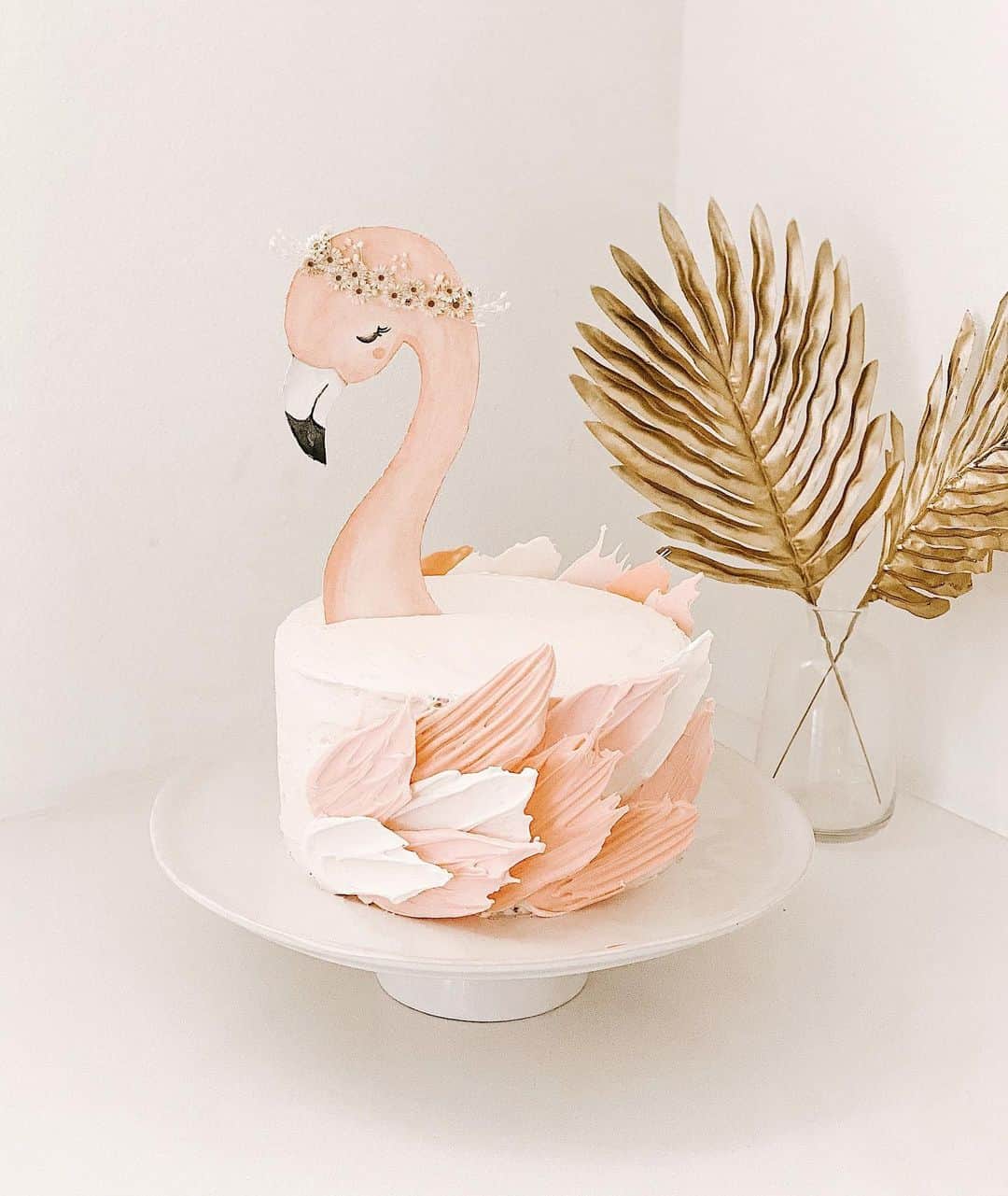 ケリー・マレーのインスタグラム：「Rys flamingo cake that was surprisingly more simple than it looks! A lot of you asked for a tutorial on stories but I suck at those and promise you could do it too with a little patience: @odettewilliams chocolate cake recipe (8” stacked....vanilla would have been better but my kids only eat chocolate!)/ vanilla buttercream frosting / candy melt wings / hand painted head on thick watercolor paper / mini dried flower crown. You got this 👊🏼」