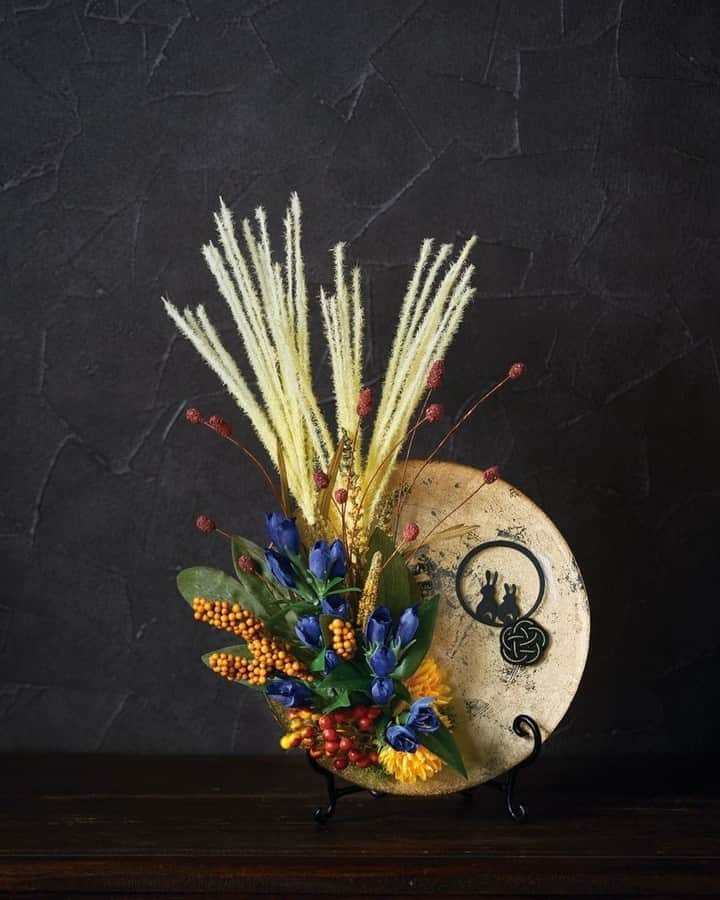 東京堂アーティフィシャルフラワーMAGIQのインスタグラム：「・ 【アーティフィシャルで季節を迎える】 ～Autumn Color Flower (オータムカラーフラワー）～ ・ CM2201-GD　オーブプレート FM7238-13　すすきピック FM7500-3　オータムベリーピック FM6814　ワレモコウ FM501-4　ベルエマムピック ZP174　お月見ピック MH580-20　金入り梅結び GZ22　アレンジフォーム25ｍｍ DO61071-730　アイスランドモス ND44319　イーゼルタンゴSS SJ530-20　オアシスカラースプレー ・ 【You Tube TOKYODO公式チャンネル】 見て学べて役立つ、お花に関する動画満載!!! https://m.youtube.com/channel/UCyD95_Gb0wQhvTRm9FDJnsQ 【チャンネル登録】お願いします Please subscribe to my channel  请注册 ❗️ 채널 등록 고마워요 ・ #TOKYODO #MAGIQ #MAGIQのある暮らし #東京堂 #アーティフィシャルフラワー #アーティフィシャル #アートフラワー #造花 #花のある暮らし #花のある生活  #花好きな人と繋がりたい #フラワーデザイン #フラワーアレンジメント #フラワーアレンジ #アレンジメント #花を飾る  #インテリア #インテリアフラワー #フェイクフラワー  #artificial #artificialflower #flowerofinstagram #flowersoninstagram #autumnflowers #花藝##꽃스타그램 #조화」