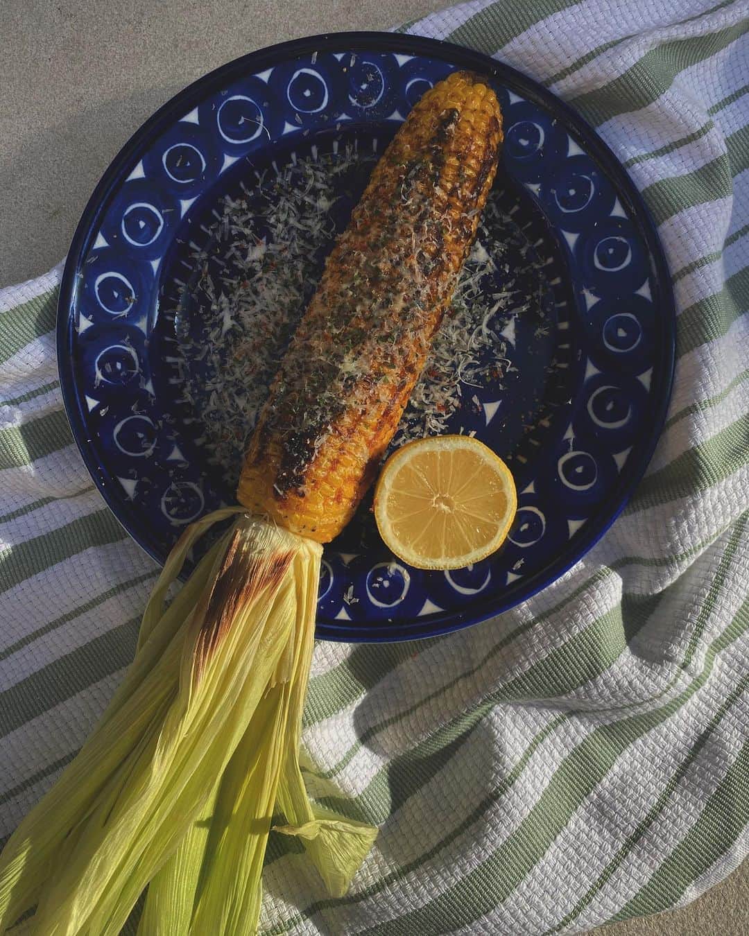 JUNNAのインスタグラム：「先日アトリエに届いた 箱いっぱいの青森県産「 #嶽きみ 」🌽  事務所のみんなで大喜び  私はデザイナーさんオススメの メキシカン グリルド コーンにチャレンジしてみました  ARABIAのブルーにコーンが映える  簡単で美味しくて見た目にも可愛い  皮を三つ編みにしたけど ほどけちゃった〜  ライムが無かったのでレモンで🍋  味が濃くて甘〜い「嶽きみ」 茹でても生でも、グリルでも美味しかった🥺  ご馳走様でした🙏  #青森 #コーン #とうもろこし #コーン #メキシカン #だけきみ #トウモロコシ #🌽#お家カフェ #おうちごはん #アラビア#ARABIA#器#おやつ#グリル#mexicanfood」