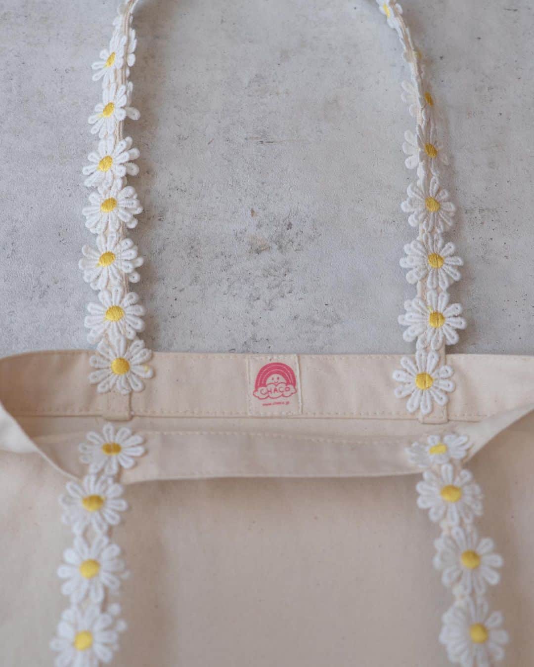 waco⭐️CHACOのインスタグラム：「マーガレットエコバッグ🌼 ずっと作りたかった取手がマーガレットのバッグを作りました。 耐久性を持たせるためマーガレットは二重に、芯にも紐を通しています。 とっても可愛くできたので、ぜひアクセサリーと合わせて使っていただきたいです。  CHACOマーガレットエコバック 2500円+税 販売は明日8/25火曜日21:00〜 お届けは11月の予定です。」