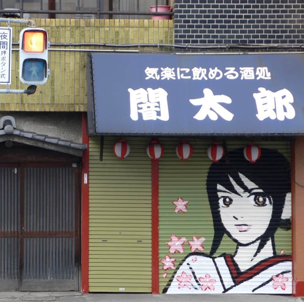 江口寿史のインスタグラム：「闇太郎のシャッターの絵を描いた2006年の画像出てきた。14年経ったんだねえー。９月24日の夜から25日の昼にかけて描いた。（徹夜で描いたわけではない。途中寝に帰りましたよ） 最初横顔描いてたんだけどイマイチで、一度消して描き直した。描き上がった時には桜の花が舞ってたんだけど、「アンタ、ちょっとソレ派手過ぎるから花消して」とマスターに言われ、今の絵に落ち着きました笑。」