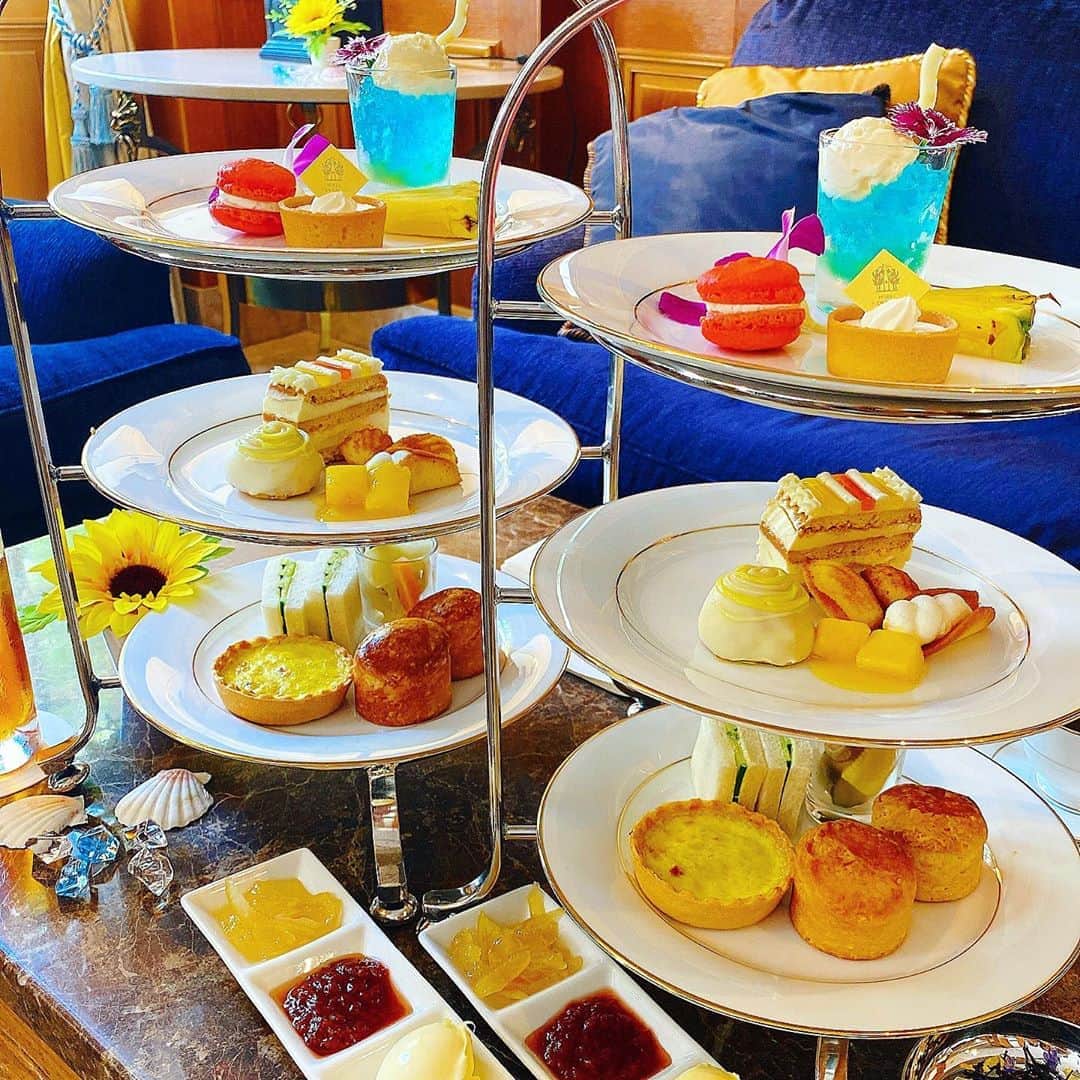 のインスタグラム：「#afternoontea #hotelnewgrand  横浜 ホテルニューグランドさんの「サマーアフタヌーンティー」でございます〜 ・ ・  伝統的メニューが好印象〜💕😌✨ ・ ・ 例えば、古典的なバタークリームのケーキ(おいしく食べられる所 わりと希少です❗️)や、ラムボール(ラム酒、バタークリーム、シナモン、プラリネを加えて丸め、溶かしチョコレートでコーディング) など ニューグランドさんならではのラインナップや、 ・ ・ スコーンにはクロテッドクリームがた〜っぷり♪(← 「たっぷり 」のセンスが合うのが重要なの ♡ 足りない時も しばしばだから。😆笑) ・ ・ きゅうりサンドイッチはマヨネーズから手作りされるなど、至るところに後藤シェフの丁寧な技が光ります✨ ・ ・ クリームソーダやパイナップルのカラフルな夏らしさも素敵♡おいしく楽しく頂きました。夏メニューは8月末までなので、お早めに〜♡ ・ ・ ホテル内も素敵な内装ですよね。 ご一緒したさとぴーちゃんも #ホワイトコーデ で、更に写真撮るのが楽しくなり動画にもまとめちゃいました。😆 あ、私は 洋服は1年中、白しか着ないですが〜 😉🤣💕笑 ・ ・ 秋の、更なるクラシックなアフタヌーンティーや、モンブランフェアも楽しみ♡お招きに感謝でございます🙏 ・ ・ #ホテルニューグランド#ホテルアフタヌーンティー#アフタヌーンティー#里井真由美#フードジャーナリスト里井真由美 #さといいね#ありが糖運動#モンブラン#モンブランの世界#ヌン活#横浜」