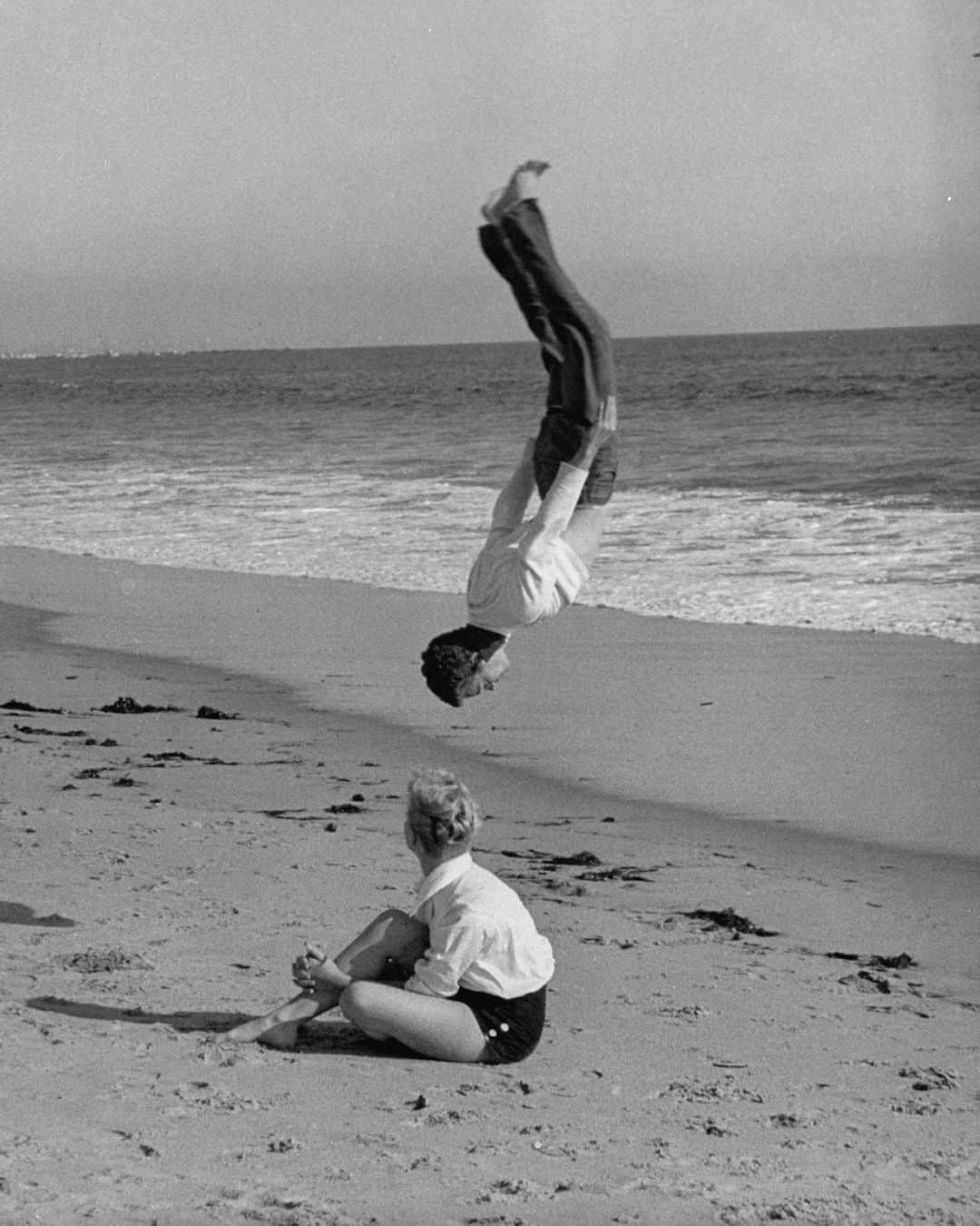 lifeさんのインスタグラム写真 - (lifeInstagram)「Actor Russ Tamblyn on the beach with girlfriend Venetia Stevenson. According to the August 1, 1955 issue of LIFE—in which this photo appeared—young Tamblyn is performing "a love-propelled backflip." (📷Allan Grant/LIFE Picture Collection) #beachlovers #1950s #russtamblyn #backflip」8月26日 6時20分 - life
