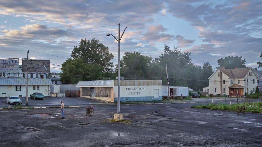 のインスタグラム：「#GregoryCrewdson: "These pictures are a meditation on brokenness, a search, a longing, and a yearning for meaning and transcendence. The figures are surrounded by vast decaying industrial landscapes and the impinging nature―and there’s a certain underlying suggestion of anxiety. But I hope in the end the theme of nature persisting, and of figures seeking out light, offers hope for renewal, even redemption." —Gregory Crewdson  Gagosian is pleased to present "An Eclipse of Moths," an exhibition of new work by Gregory Crewdson opening on September 24 at Gagosian, Beverly Hills.  This exhibition comprises sixteen large-scale panoramic exteriors, shot using Crewdson’s famously meticulous production techniques and longtime technical crew. Set in a postindustrial urban landscape, the series depicts locales of removed isolation, each of which Crewdson spent months scouting and staging before production began: a taxi depot, a traveling carnival lot, an abandoned factory complex, defunct bars and diners, and vacant storefronts. Follow the link in our bio to learn more about the exhibition. __________ #Gagosian @crewdsonstudio  Gregory Crewdson, "Redemption Center," 2018–19, digital pigment print, image: 50 × 88 7/8 inches (127 × 225.7 cm), framed: 57 × 96 × 2 inches (144.8 × 243.8 × 5.1 cm), edition of 4 + 2 AP © Gregory Crewdson」