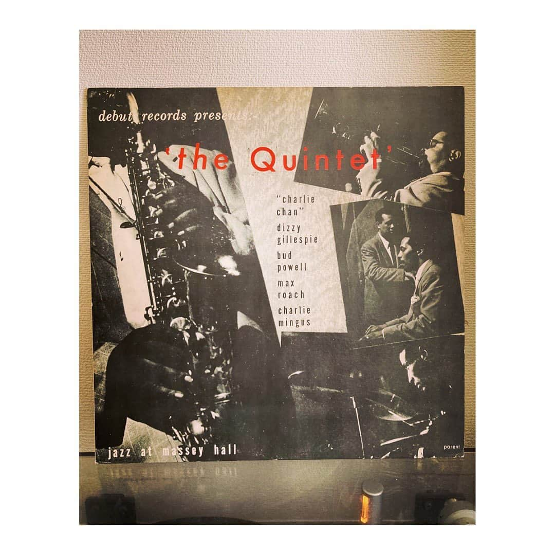 林幸治さんのインスタグラム写真 - (林幸治Instagram)「The Quintet ‎– Jazz At Massey Hall  1953年5月にカナダのトロントで開催されたModern Jazz Summit MeetingにおいてDizzy Gillespie、Charles Mingus、Charlie Parker、Bud Powell、Max RoachのクインテットがMassey Hallにて録音した白熱のライヴを記録した名盤。  ジャズの事を語るほど詳しくはありませんが、これはすごいメンバーですね。それぞれが負けてたまるか、と、しのぎを削っているような熱さを感じます。が、調べてみるとチャーリーパーカーは手ぶらでやってきて地元の楽器屋で借りた練習用のサックスでステージに上がったとか、ディジーガレスピーは同時刻にやっていたボクシングの試合に夢中でソロパートが終わると楽屋にひっこんでテレビ中継を観ていたとか、それが気に食わないミンガスと険悪なムードになっていたとか、バドパウエルは病み上がりで車椅子に乗って看護師に伴われてステージに上がったとか散々なコンディションだったようで。  ボクシングの試合に客を取られて2500人収容の所に700人しか入らなかったらしい。  いろいろ無茶苦茶な状況であるが故のテキトー感がある意味で勢いと熱を生み出しているのかもしれません。  とりあえずドラムのマックスローチのソロ、かっこいい。  #vinyl #1956 #thequintet #1976japanpress #mono #nowspinning #jazz」8月27日 16時24分 - tct_koji_hayashi