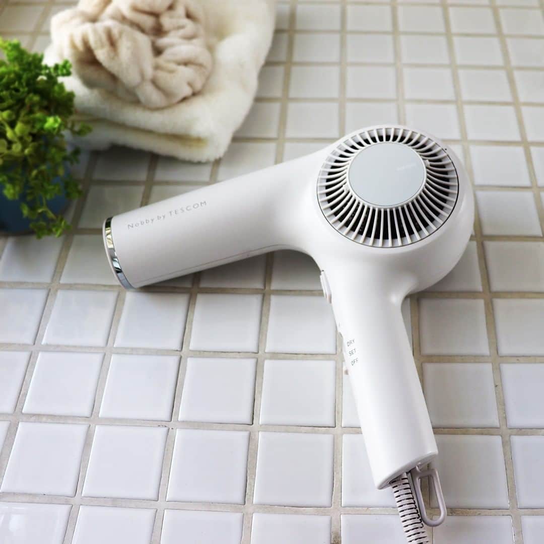TESCOM テスコムのインスタグラム：「＼風速×軽量ボディで手軽にサロン帰りの仕上がりを✨／ . テスコム製品の中でも高い人気を誇る #nobbybytescom ✨ 美容室で使用されているNobbyをベースに製品を開発しています。 . プロのヘアドライでは、根元を乾かす速い風が重要！ そこでプロフェッショナルプロテクトイオンヘアードライヤーNIB2600は、サロン仕様の風速はそのままに、使いやすさを追求し20%の軽量化※1を実現👍 540gの軽量ボディでより持ちやすく、“手軽にサロン帰りの仕上がりを”という方にオススメです✨ . - - - - - - - - - - - - - - - - - - - - - - - - - ●商品名：プロフェッショナル プロテクトイオン ヘアードライヤー ●品番　：NIB2600 ●カラー：アッシュ／ブラック - - - - - - - - - - - - - - - - - - - - - - - - - ※1 当社従来品比較（NIB2000） @tescom_beauty  . Nobbyに関する情報は@tescom_pro  キッチン家電に関する情報は@tescom_kitchen  にてご紹介中！ . 毎日使うヘアアイテムは #テスコム または #TESCOM で検索してみて下さいね♡ テスコムのInstagramでは、自分らしさを追求したあなたのキレイづくりに役立つ情報を毎週発信しています！ . . #美容  #ヘアスタイル  #スタイリング  #ヘアケア  #美髪  #美活  #ビューティー  #美容好き  #モテ髪  #モノトーンインテリア  #ドライヤー  #美容女子  #プロフェッショナル  #美髪ケア  #美容家電  #髪質  #モーニングルーティン  #速乾  #サラサラ髪  #ヘアドライヤー  #サロンクオリティ  #ヘアードライヤー  #速乾ドライヤー  #私にできるサロンクオリティ  #朝のスタイリング  #大風速  #ノビテス」