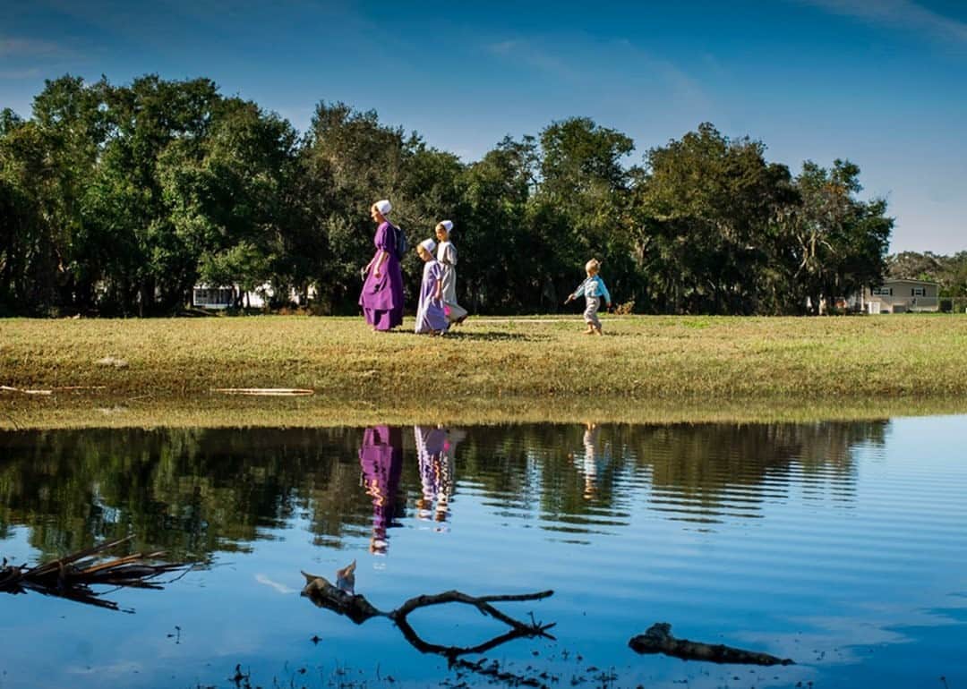 National Geographic Travelさんのインスタグラム写真 - (National Geographic TravelInstagram)「Photo by @dina_litovsky  An Amish family walks through Pinecraft Park. Every winter Amish and Mennonite travelers from all over the United States travel to Pinecraft, a small community in Sarasota, Florida. Starting out as a tourist camp in the 1920s, it has since become a popular vacation spot. Pinecraft is a unique place where all different Anabaptist denominations escape the winter together and mingle among each other. The usual rules are a bit looser, turning a blind eye to the use of cell phones, cameras, and bicycles while encouraging recreational activities.  For more images, follow me @dina_litovsky.」8月28日 19時04分 - natgeotravel
