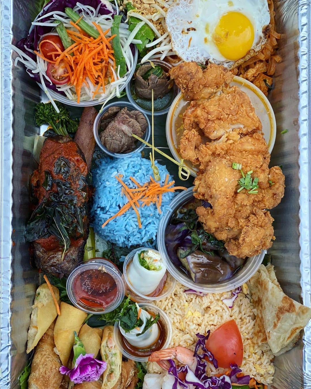 Antonietteのインスタグラム：「On our picnic at the park in SF we ordered The Little Lao set from @thaifarmhouse. It was a feast for the senses! Arranged aesthetically pleasing in a large catering tray, we devoured this in the park with onlookers curious to see what we were eating. 😬 Come on, social distance, 6 feet bro!😷⬅️6️⃣➡️😷Oh my gosh, it was so good. The tray came with fresh rolls with peanut sauce, samosas, egg rolls, papaya salad, num tok rolls made with grilled wagyu beef flank, hat yai fried chicken, shrimp fried rice, pad Thai, spicy eggplant, blue rice and 2 Thai ice tea OR 2 Singha Beers...and a kids meal of pad see ew! So well done, so delicious. Thanks @thaifarmhouse for a memorable meal! 😋」