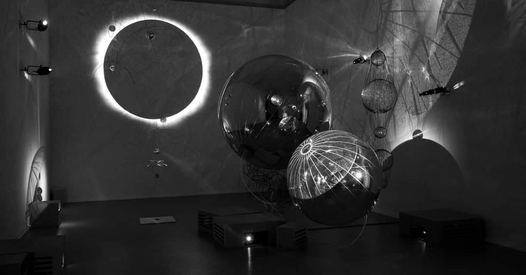 のインスタグラム：「Nell’installazione “A Thermodinamic Imaginary” Tomás Saraceno crea un ambiente in cui sfere sospese simulano un Cosmo in miniatura e proiettano le loro ombre sulle pareti. In questo spazio anche il nostro corpo diviene parte di una scenografia in bianco e nero, retto da un delicato gioco di ombre e di invasioni di traiettorie. Esplora il Cosmo di Tomás Saraceno visitando la mostra. Fino al 31 agosto puoi comprare il biglietto online senza costi di prevendita: trovi il link in bio.  Crediti: Tomás Saraceno, “A Thermodynamic Imaginary”, 2020. Installation view of Aria, Palazzo Strozzi, Florence, 2020. © Photography by Studio Tomás Saraceno  #TomasSaraceno @studiotomassaraceno #StudioTomasSaraceno #PalazzoStrozzi #Aria #Eclisse #Eclipse #Moon #Sun #Alignment #Firenze #Florence #Tuscany #Toscana #Mostra #Exhibition #ArtGram #ContemporaryArt」