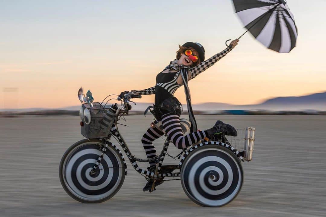ボニー・モーガンのインスタグラム：「One year ago the magically amazing photographer @jamenpercy happened to capture this shot of me in my natural habitat speeding by on The Trike Of Epic Awesomeness build week @burningman! He would become one of my favorite people! Thank you @jamenpercy hope to see you somewhere in the Multi-verse ❤️🔥✨#wheresmyportalgun #burningman #playaclown #adventuresofbendybonnie #jamenpercy #stripes #home #thetrikeofepicawesomness #industwetrust #multiverse #shenanigans #bendybonnie」
