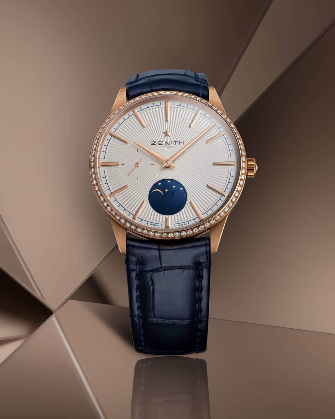 ゼニスのインスタグラム：「#Elite: Capturing the grandeur of the night sky to is one of the most poetic complications of all: Elite Moonphase in 36mm 18k rose gold case with diamond-set bezel, and silver-toned sunburst-pattern dial.  #Zenith #ZenithWatches #Watches #Watch #Watchesofinstagram #Watchfam #WatchoftheDay #Luxury #WatchAddict #Watchcollector #Horology #DailyWatch」