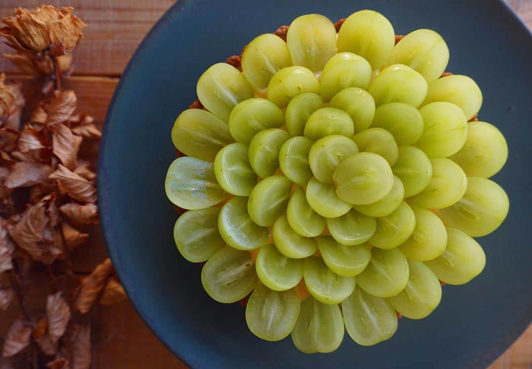 CHIKAのインスタグラム：「シャインマスカットのタルト♡ やっぱりこの時期は作りたくなる🍇 プレゼント用に作ったのに土台にちょっぴりシナモン入れて、カスタードクリームにはカルダモンを🙈💓 カスタードクリームの仕上げは生クリームを少しとラム酒を切らしてたからウイスキーも🤫❣️ 大人のタルトになりました♡ (食べてないから美味しかったのか今でもドキドキしてるけど😂) 誰かのために作るタルトはドキドキしながら美味しくできるといいな、喜んでくれるといいな、と色んな気持ちがたっぷり詰まってます♡ そんな気持ちをこれからも大事にしていきたいな♡ 喜んでもらえてよかった‪‪☺︎‬ *. *. *. #タルト#シャインマスカット#お菓子作り#tart#🍇#🎂#cake#平野日奈子」