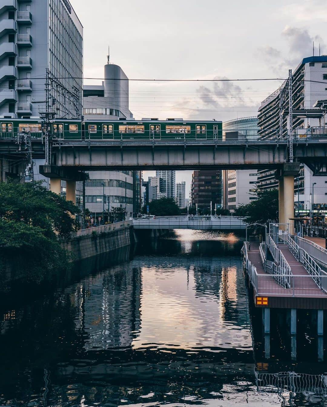 東急電鉄さんのインスタグラム写真 - (東急電鉄Instagram)「. 東急電車と風景が綺麗に見えるスポットのご紹介です。 桜の名所として有名な目黒川。定番のお花見スポットは東急東横線中目黒駅のそばにありますが、そこから下流に向かっていきますと東急池上線五反田駅付近にたどり着きます。そのすぐ近くで目黒川を渡る電車を撮影することができます。 オススメする撮影時刻は、昼から夜に移る西日が差し込む頃。 夕焼け色に染まるマンションやオフィスビルが立ち並ぶ街を背景に高架線を渡る電車は美しく、思わず足を止めてしまうほど。 どこか人々の営み・生活の大切さを感じさせてくれる風景です。 夜になると、電車の明かりが鏡のように川面に反射して、それもまた面白い風景になりますよ。 （東急池上線　五反田駅） . Spots where the Tokyu line trains run through gorgeous backdrops. Meguro River is a coveted destination for cherryblossoms. For most flower-lovers, the usual spot is just next to Nakameguro Station on the Tokyu Toyoko Line, but if you head downstream you’ll make your way towards Gotanda Station on the Tokyu Ikegami Line. Here’s where you’ll find a hot photo spot where trains cross the Meguro River. We recommend visiting in the afternoon/evening, when the sun is beaming in from the west. The area is lined with office buildings and high rises as they’re washed with the light of sunset. It’s truly a breathtaking moment as the train passes on the overhead tracks. Catch a glimpse of this scene and you’ll stop to reflect on the quieter moments and people in life. At night, the lights of the trains reflect like lamps on the river’s surface, making for another snap you’re sure to love. (Gotanda Station  Tokyu Ikegami Line ) . #五反田 #gotanda #tokyo #東京 #池上線 #train_vision #japantrain #japanesetrain #電車 #鉄道 #鉄道写真 #鉄道好き #鉄道ファン #鉄道のある風景 #鉄道好きな人と繋がりたい #撮り鉄 #railways_of_our_world #railwayphotography #trains_worldwide #railfan #japantrip #discovertokyo #visitjapanjp #tokyu #東急 #東急沿線 #일본여행 #東京自由行 #東京景點 #hellofrom」9月1日 16時57分 - tokyu_railways