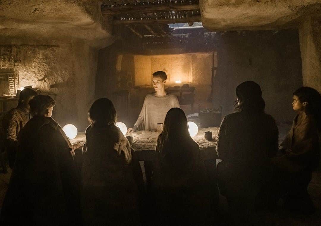 ジョーダン・ロクランのインスタグラム：「Two days to go.... @raisedwolvesmax on @hbomax from September 3rd! [Image description: Six children are gathered around  Mother at a large stone table. The room is lit by a soft glow from the lights on the table and a small fire in the background.] #RaisedByWolvesMax #RidleyScott」