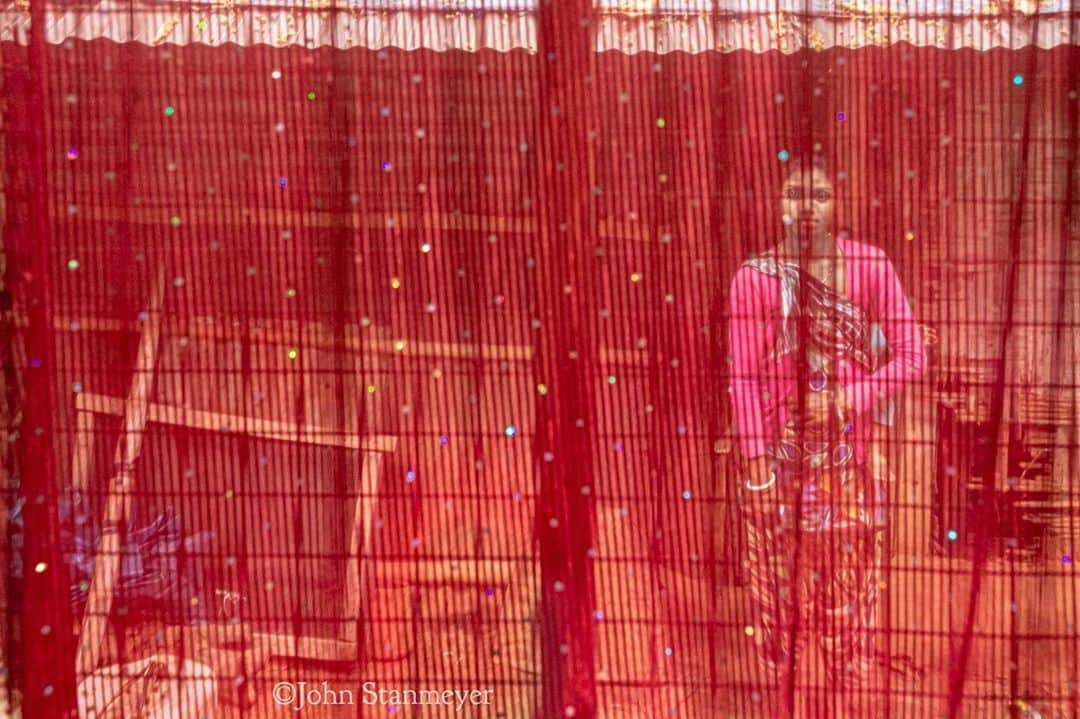 のインスタグラム：「A few days ago, I shared a photograph of Rajini’s little boy, Tanu, sleeping on his mama’s bed at their home in Caron village in West Bengal. This is the ever pleasant mama, through all the beautiful red and sparklingness of her curtain. Ranjini was carrying Tanu wrapped to her back while sweeping the courtyard. Was a lovely afternoon with the family of immense kindness, discussions on working in the tea plantations, and many warm cups of milky sweet chai I can’t easily forget. ⠀⠀⠀⠀⠀⠀⠀ India’s Daunting Challenge: There’s Water Everywhere, And Nowhere - Chapter 8 of the @outofedenwalk, my latest story last months (August 2020) issue of @natgeo magazine. ⠀⠀⠀⠀⠀⠀⠀ #portrait #redcurtain #redness #india #westbengal #caron #home @natgeo @outofedenwalk #walkingindia #edenwalk」