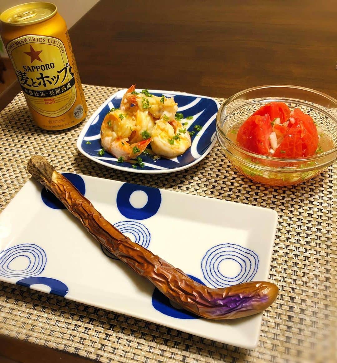 のインスタグラム：「#おうちごはん  今日のメニューは、 #ガーリックシュリンプ 、 大長茄子の女気一本焼き。 トマト丸ごと出汁浸し玉ねぎ詰め詰め。 今日もごはんとビールが美味い！ 明日は1日おうち作業だからニンニク思い切り摂取したわ😋 #夕飯 #おつまみレシピ #おつまみメニュー」
