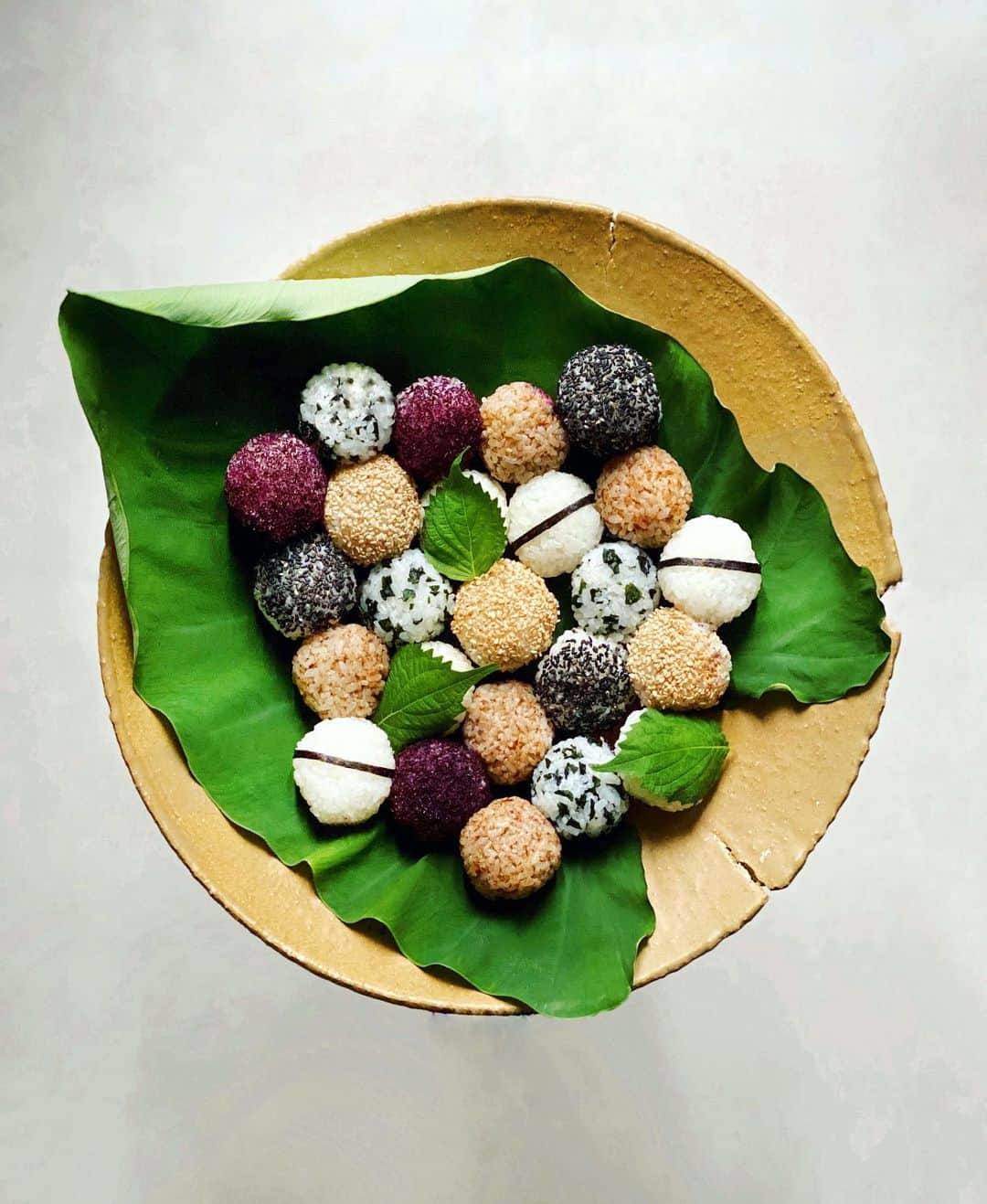 のインスタグラム：「Taro leaf and rice balls #onigiri  里芋の学名はColocasia esculentaだそうで、 Colocasia→サトイモ属、esculenta→「食用になる」という意味だとか📝 . 今朝、野菜畑で水やりをしている時、 里芋の葉にかけた水が大粒になって跳ね返ってきて。 その巧妙に水をはじく姿が あまりにきれいで神がかり的だったので 1枚拝借することに。 そう、これはやっぱり日本の心「おにぎり」を 盛らないとね な〜んていいながら作ったおにぎりです😊 . #里芋　 #野菜 #おにぎり」