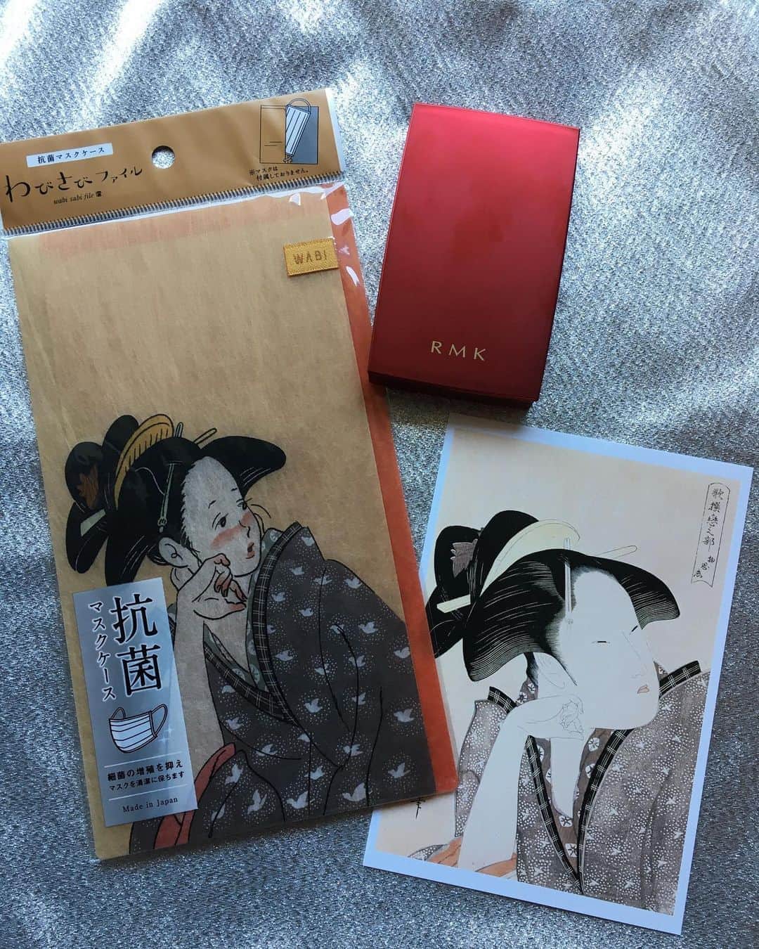 のインスタグラム：「東京都美術館で開催中の「The UKIYO-E 2020 ─ 日本三大浮世絵コレクション」展へ。 行った友人たちが口々に「量が凄いから時間と体力のある時に！」と言っていたけれど、まさに…あらゆる北斎作品から希少作、名作まで、浮世絵200年の歴史が集結していました。 ジャポニスム旋風、巻き起こるはずです🌊 写真は、グッズの抗菌マスクケース、たなかみさきさんの「歌撰恋之部 物思恋」 ポストカードは、喜多川歌麿「歌撰恋之部 物思恋」 それからグッズではないですが、赤いコンパクトは、 #rmk の、江戸桜ルーセントパウダー。rmk2020秋冬は、江戸時代まで遡り、浮世絵師や女性たちの着物あそびに着想を得たそうで、特に、喜多川歌麿の美人画からヒントを得ているそう。 江戸時代最高峰の肌は「真珠肌」。そんなツヤと発光感のある肌へ導くパウダーだとか☺️ マスクでファンデが落ちやすいので、 今はとにかく、顔の表面をサラサラにすることを心掛けています。 #浮世絵 #rmk」