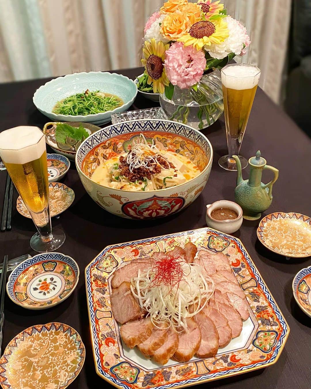 谷中麻里衣のインスタグラム：「Flowers brighten everything up 🌸 . お花とお皿の華やかさで、茶色い料理が彩り豊かに見える不思議🥰笑 チャーシューも坦々豆腐も、前回と少し変えてみたらより好みでした💕 . 餃子、羽根が綺麗にできると嬉しい✨ 昔はうまくできずに片栗粉のネバネバだらけだったな😂 . #チャーシュー#焼豚#おうちごはん#中華#おうち中華#餃子#ギョーザ#麻里衣ごはん#有田焼#賞美堂#其泉#花#ひまわり#向日葵#cooking」