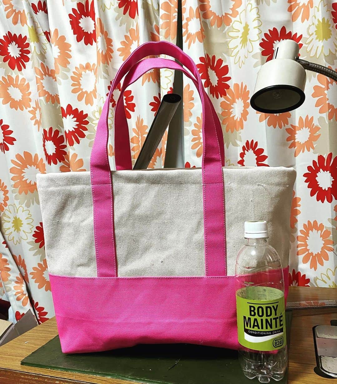 のインスタグラム：「オーダーいただいたトートバッグ。  生成の帆布にピンク帆布で。  裏貼りつけてポケットもついています。  ペットボトルと比べてわかるように結構大きめです。  なんとなく色合いがどこでもドアっぽい。  しっかり丈夫にできました！！  カバンのオーダーなんかも受け付けております、それ以外もできることはやりますしできないこともやってみるのでなんでもお気軽にお声がけ下さい。 https://orcute.official.ec/items/31399059  #ハンドメイド #トートバッグ #帆布 #工業ミシン」