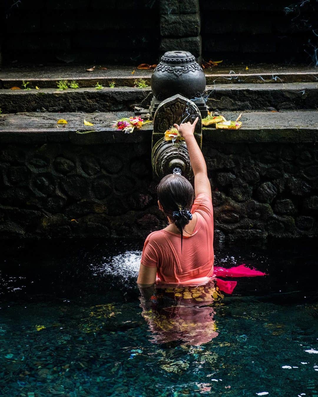 National Geographic Travelさんのインスタグラム写真 - (National Geographic TravelInstagram)「Photos by @francescolastrucci / A pilgrim takes a blessing by one of the fountains of the Pura Tirta Empul (Temple of the Holy Spring). The Balinese visit this place of worship to purify themselves under the sacred waters of the pools, fed by the springs flowing from the side of the sacred mountain. Built in 962 and dedicated to Vishnu, the structure is made up of a set of temples near the village of Manukaya in central Bali. The persistent scent of incense burnt on offer to the gods and the bright colors of the flowers on the fountains make the experience inside the temple highly evocative and mystical. Follow me @francescolastrucci for more places, daily life, and stories around the world. #bali #rituals #dailylife」10月6日 5時06分 - natgeotravel