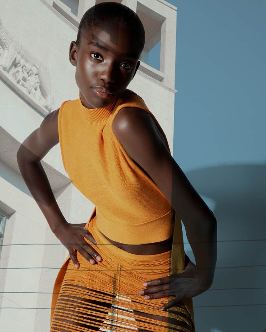 サルヴァトーレ・フェラガモのインスタグラム：「Maty Fall channels a nonchalant confidence, in a slashed burnt orange skirt ensemble, silhouetted against illusory locals from Milan, mirroring the indomitable spirit of a city getting back on its feet after a struggle with the pandemic. #FerragamoSS21」