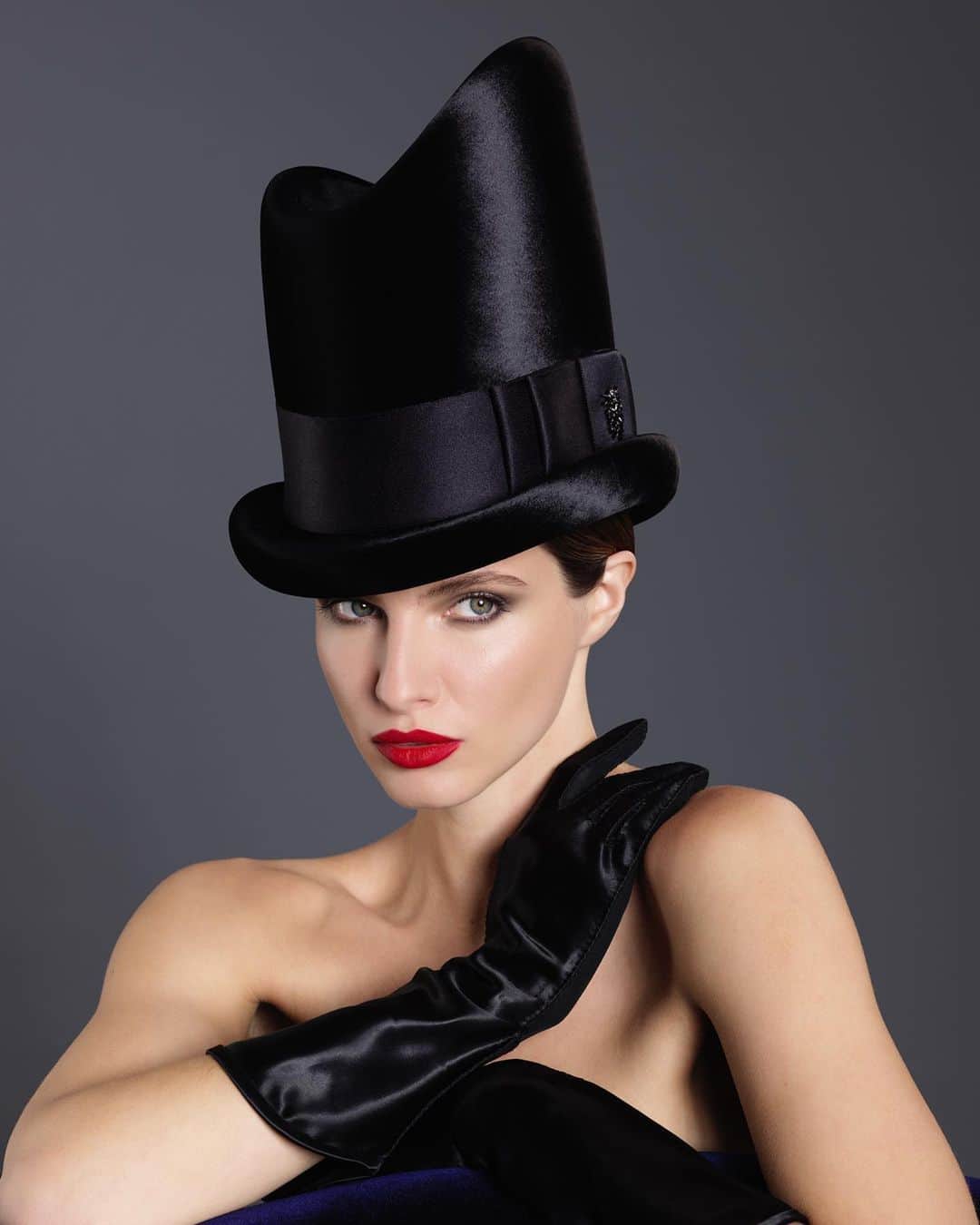 のインスタグラム：「Philip Treacy Autumn/Winter 2020.  @georginahhoward wears Mae West’s personal black satin gloves and a Couture panne velvet top hat. Photographed by @dimitristheocharis   Second Picture: Los Angeles, Aug. 27 - ON STAND - All dolled up in black satin, Mae West took the stand yesterday to testify in the $100,000 plagiarism suit filled against her by two writers.」
