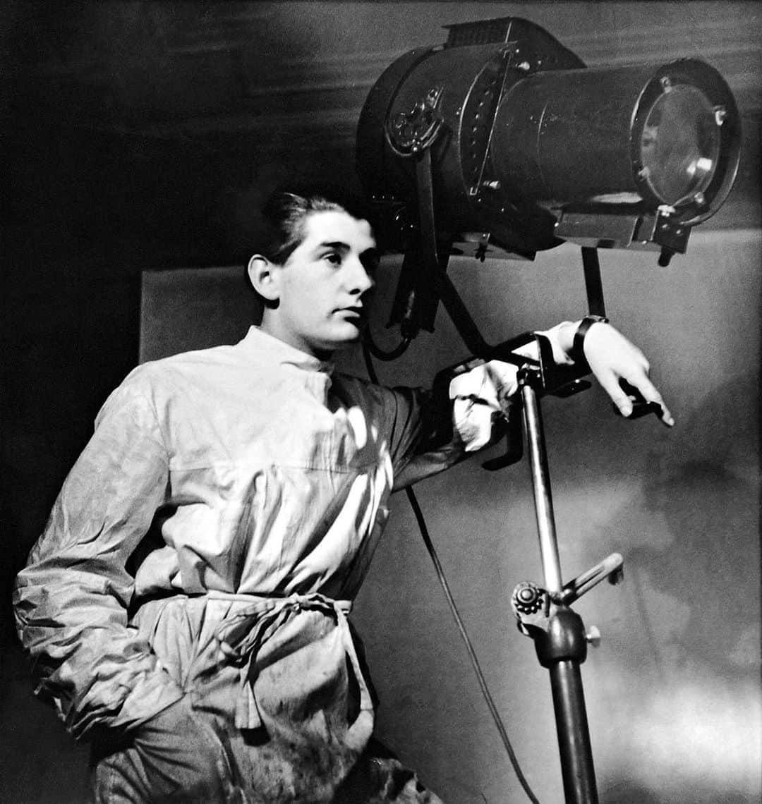 Vogue Italiaさんのインスタグラム写真 - (Vogue ItaliaInstagram)「Helmut Newton, Self-Portrait in Yva’s Studio, Berlin 1936  Helmut Newton is immediately recognizable in this early self-portrait. At the age of 16, he photographed himself in the studio of the famous Berlin portrait and fashion photographer, Yva, whom he assisted from 1936 to 1938. The studio was located in Schlüterstrasse/corner of Kurfürstendamm, in an upper middle-class neighborhood. However, a difficult and dangerous time began for Jewish photographers. By then, some were already banned from their profession, and others later perished in concentration camps, including Yva. Newton chose to wear a lab coat in this self-portrait, underscoring his role – helping with retouching, developing film, and other work in the darkroom. He leans against a large studio lamp, his pose casual and confident. At that point, his entire life was still ahead of him – his gaze is directed into the distance, into the future. The studio spotlight visible in the picture is turned off, but another one seems to be directed at Newton as the subject of the picture. In fact, the entire scene is perfectly lit, with an almost cinematic feel. In the left half of the image Newton stands out in his white outfit against the studio’s dark background, while the dark lamp is positioned in front of a lighter background. Later, Newton frequently used dramatic light contrasts to shape the pictorial space of his photographs.  In another self-portrait from the same year, taken at the same location and with a similar visual composition, Newton staged himself quite differently: with hat and coat, camera at the ready – like a roving reporter in the style of the legendary Egon Erwin Kisch. A short time later, he fled Nazi Berlin in 1938 and traveled by ship to Singapore, where he worked as a photojournalist for the Straits Times. However, he did not deliver the required pictures fast enough – it was the first and only time he failed on his path to becoming a famous photographer. Nevertheless, these two very different self-portraits from Berlin mark the start of his international career.  Vogue Italia’s takeover by Matthias Harder, director of the @HelmutNewtonFoundation.」10月3日 0時28分 - vogueitalia