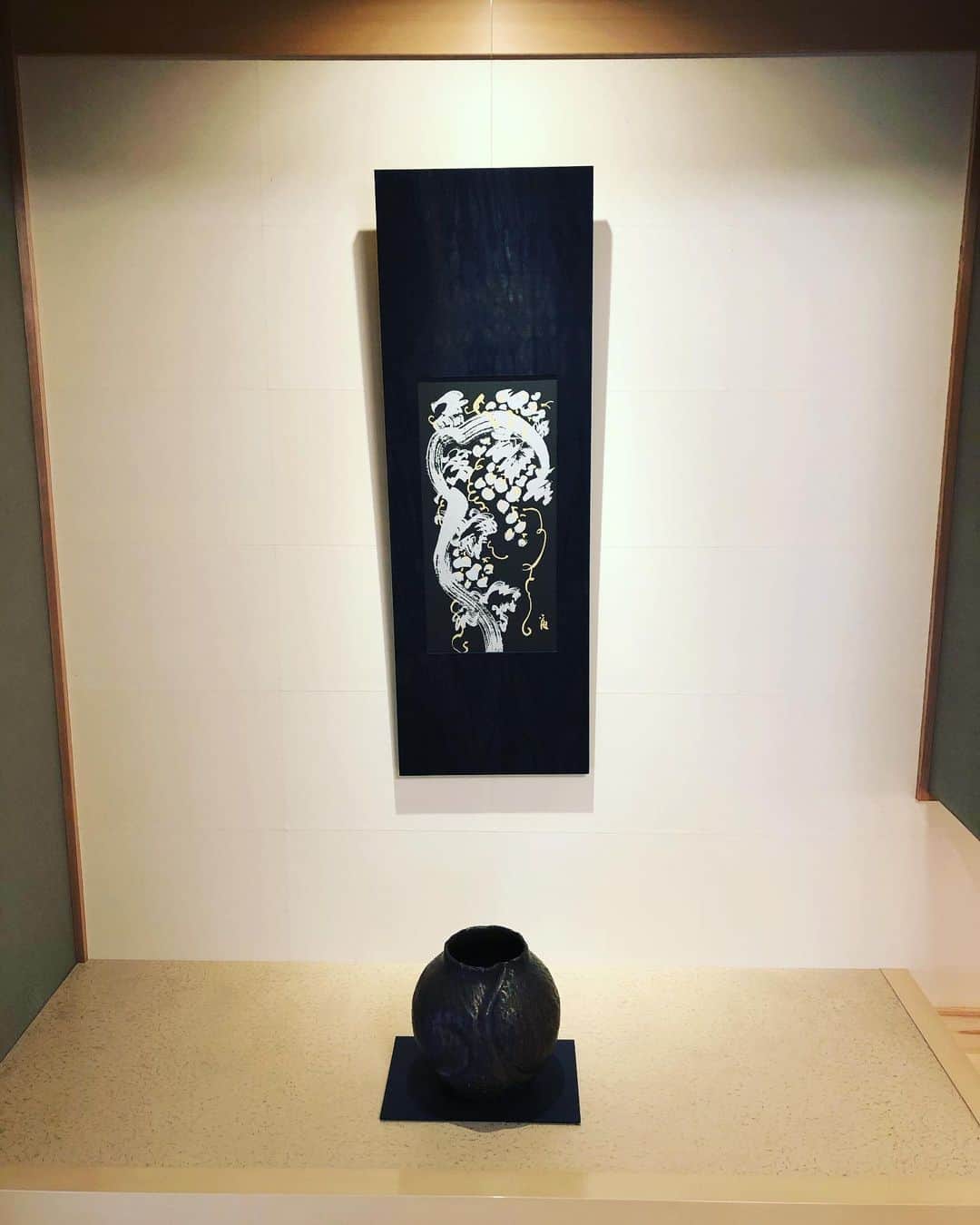 デザオ建設北野展示場のインスタグラム：「皆様こんにちは！ デザオ建設北野展示場です！  今回は床の間の設えを変えていただいたのでそちらをお届けします💮 秋らしくなってきて、月も跨いだと言うことで！また違った秋の気配の床の間です。ブドウの絵の表具です🍇 柿渋と藍で染めた秋らしく渋い色合いの素敵な表具……そして黒い壺がまた良い感じに締まった印象を与えてくれますね😳 背景の和紙の壁と白漆の床の間に良く映えます😍  実はこの壺、北野展示場にいるどのスタッフよりも先輩なんだとか。新入社員と中の人でとりあえず拝んでおきました。  季節ごとに和室の設えを変えておりますので、ご見学の際は和室でのんびりくつろぎながらご覧ください😃 ご来場お待ちしてます🙇🏻‍♂️🙏🏻💕  #和室 #床の間 #表具  #壺 #なんと長老   #秋らしく葡萄の絵 #一戸建て​ #マイホーム   #家 #住宅 #工務店 #マイホーム計画  #家づくり #施工事例 #一戸建て  #myhome  #京都の注文住宅  #こだわりポイント #設計  #おうち時間  #デザオ建設​ #DEZAO #デザオ建設北野展示場 #つなぐモデルハウスとこしえ #デザオ北野スクエア #DsLABO #リフォーム​#リノベーション #注文住宅​#住宅展示場 #住宅展示場巡り」