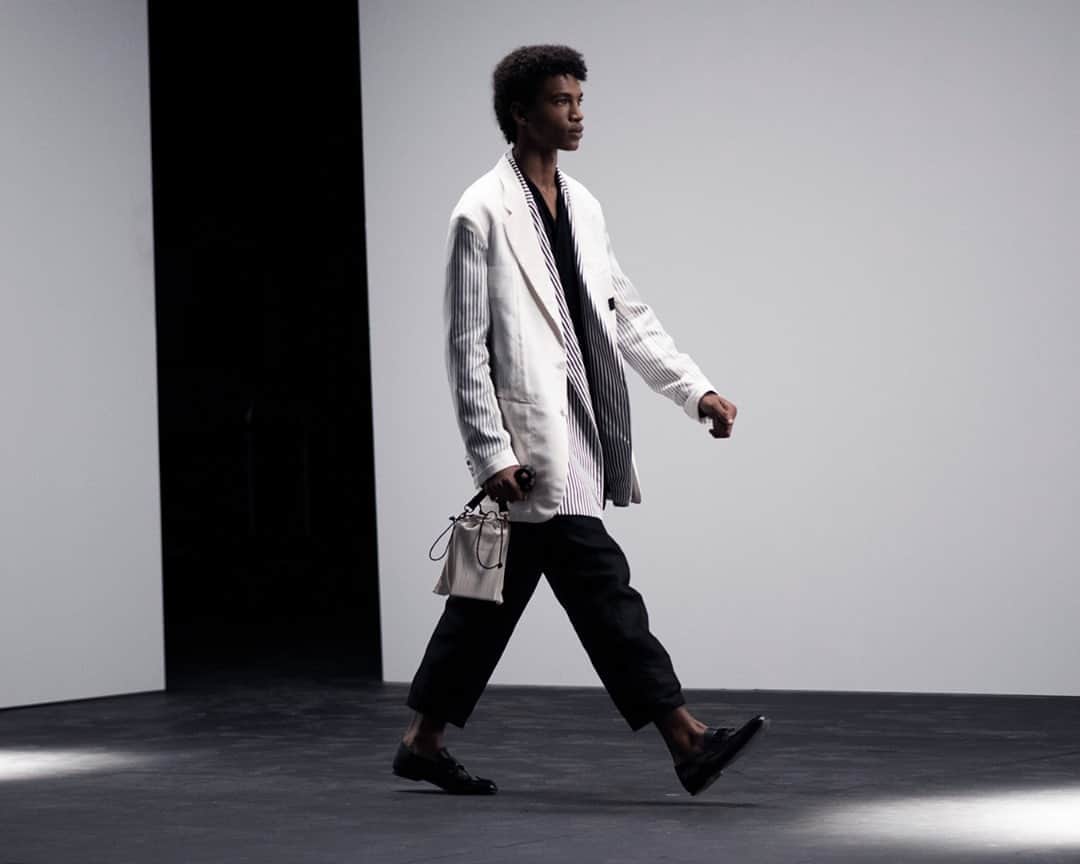 のインスタグラム：「SPRING SUMMER 2021 SHOW⁠ LOOK 8⁠ #dunhillSS21⁠ ⁠ Silk acetate reverse detail contrast jacket worn over stripe split hem jacket, with duchess silk satin wrap shirt, denim utility trousers and Link soft loafers; carrying a new iteration of the Lock bag.⁠ ⁠ Follow the link in our bio to re-live the show and to see the collection in full.⁠ ⁠ Creative Director: #MarkWeston⁠ Creative Consultant & Stylist: #ElliottSmedley⁠ Photography: @jasonlloydevans⁠ ⁠ DUNHILL.COM」