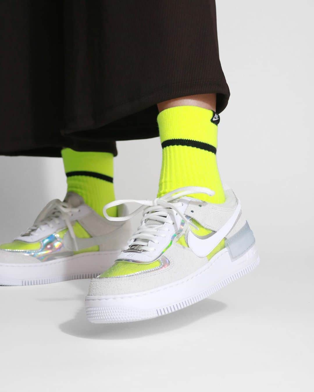 A+Sのインスタグラム：「2020. 10. 7 (web) in store﻿ ﻿ ■NIKE WMNS AF1 SHADOW﻿ COLOR : PURE PLATINUM/WH﻿ SIZE : 23.0cm - 25.0cm﻿ PRICE : ¥13,000 (+TAX)﻿ ﻿ ナイキ エア フォース1 シャドウのルーツは80年代に英国で生まれたダンスミュージックを一晩中、流す大規模なイベント "レイブ（Revolution Live)" にあります。レイブが生まれる以前はドレスアップをしてナイトクラブやディスコで音楽を楽しむ事が主流でした。しかし、アシッドハウスやテクノといった当時の最新音楽の影響からイベントの参会者のファッションもカジュアルダウンされ、60年代のヒッピースタイルにメタリックな素材を取り入れるなど、サイケデリックな装いで自由に自己表現をするスタイルへと変貌を遂げました。 このスニーカーはまさにその時代を色濃く表したデザインに仕上がっています。サイケ的要素でメタリック素材を用いたアッパーや爪先はシースルー素材を用い靴下を変えるだけで、様々なカラーへと変化します。まさに音楽の持つ無限の可能性をスニーカーに込めたデザインに仕上がっています。﻿ ﻿ Nike Air Force 1 Shadow's roots are in the big event "Rave (Revolution Live)", which plays dance music from the UK in the 80's all night long. Before the birth of rave, it was mainstream to dress up and enjoy music at nightclubs and discos. However, due to the influence of the latest music at the time such as acid house and techno, the fashion of the attendees of the event was also casually downed, and the hippie style of the 1960s was incorporated with metallic materials. Has undergone a transformation. These sneakers are finished in a design that strongly expresses that era. The upper and toes, which are psychedelic and made of metallic material, are made of see-through material and can be changed to various colors just by changing the socks. The design is finished with the infinite possibilities of music in sneakers.﻿ ﻿ #a_and_s﻿ #NIKE﻿ #NIKEAF1﻿ #NIKEAIRFORCE1﻿ #NIKEWMNSAF1SHADOW #RAVE」