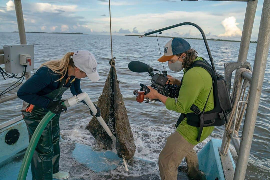 National Geographic Creativeさんのインスタグラム写真 - (National Geographic CreativeInstagram)「Photos by @CarltonWard  in the first frame, @morth_photo captures split-level video of clam farmer Ian Stone harvesting clams on his family’s lease in the Gulf of Mexico near Cedar Key. Ian’s sister and business partner @gretchstone works on the boat in the background. They will be featured in the #LastWildPlaces film about the Florida Wildlife Corridor we are producing with @insidenatgeo. In the subsequent behind-the-scenes photos, filmmakers @danny_schmidt (green shirt) and @ricksmith_media work to portray Gretchen and Ian’s lives, including setting up and interview with Gretchen. Camera assistant @leyoho got in on the action (7th photo). Please follow me @carltonward and @pathofthepanther to learn how the Florida Wildlife Corridor is vital to all Floridans and visitors. @fl_wildcorridor #keepflwild」9月12日 3時58分 - natgeointhefield