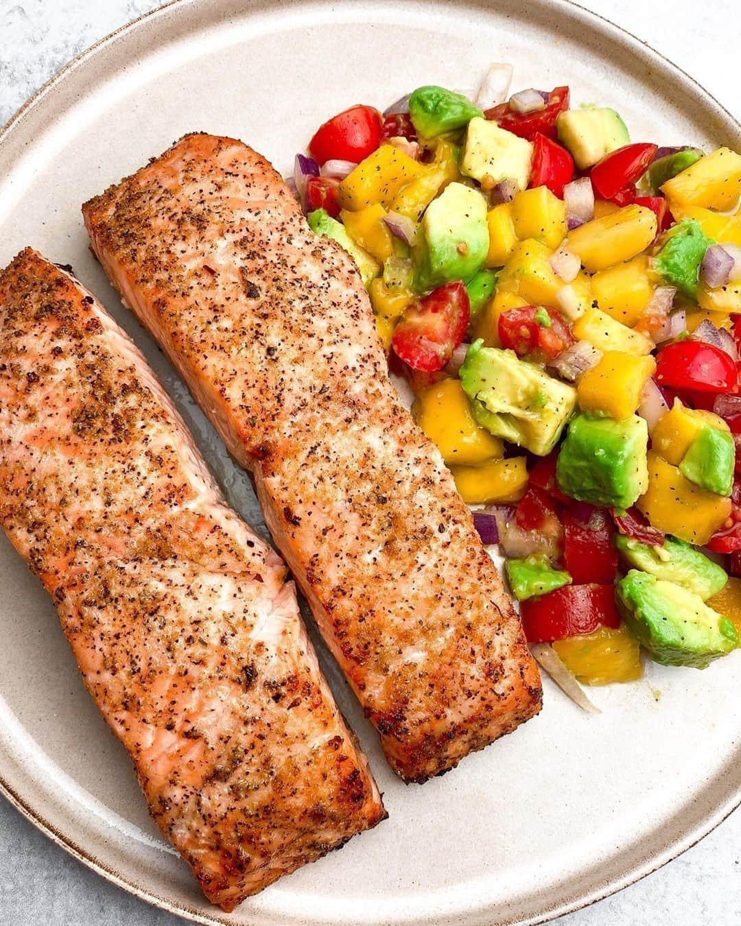 Flavorgod Seasoningsさんのインスタグラム写真 - (Flavorgod SeasoningsInstagram)「Baked Salmon with Mango Avocado Salsa 🌟 ⁣ by customer @mandaameals⁠ ⁣-⁠ Flavor God Seasoning Used: Lemon & Garlic(Perfect for Salmon)⁠ -⁠ Add delicious flavors to your meals!⬇️⁠ Click link in the bio -> @flavorgod  www.flavorgod.com⁠ -⁠ Ingredients: ⁣⁠ Salmon fillets ⁣⁠ 1 mango ⁣⁠ 2 avocados ⁣⁠ 1/4 of a medium red onion⁣⁠ Cherry tomatoes ⁣⁠ 1/2 of a lemon, juiced ⁣⁠ 1/2 of a lime, juiced ⁣⁠ ⁣⁠ Directions: ⁣⁠ • Start with your salsa. Chop your red onions & cherry tomatoes, then add to a large bowl. Add in diced avocado and mango 🥭 as well. Squeeze lemon & lime and add your salt & pepper for seasoning. Mix well. Let chill in fridge while salmon is being made. ⁣⁠ • Preheat oven to 450°⁣⁠ • Season your salmon - salt, pepper, and @flavorgod Lemon & Garlic Seasoning on both sides. Place fillets skin side down, on a baking sheet lined with parchment paper & then drizzle olive oil on top. Bake for 13-15mins. Once done, you can squeeze lemon juice on top for extra flavor! ⁣⁠ ⁣⁠ Ugh, so delicious. I always make salmon this way and it always comes out perfectly and the skin gets crispy! Love it 🤩 and this salsa pairs with it perfectly. A perfect meal to end the summer with. ⁣⁠ -⁠ Flavor God Seasonings are:⁠ 💥ZERO CALORIES PER SERVING⁠ 🔥0 SUGAR PER SERVING ⁠ 💥GLUTEN FREE⁠ 🔥KETO FRIENDLY⁠ 💥PALEO FRIENDLY⁠ -⁠ #food #foodie #flavorgod #seasonings #glutenfree #mealprep #seasonings #breakfast #lunch #dinner #yummy #delicious #foodporn」9月13日 8時01分 - flavorgod