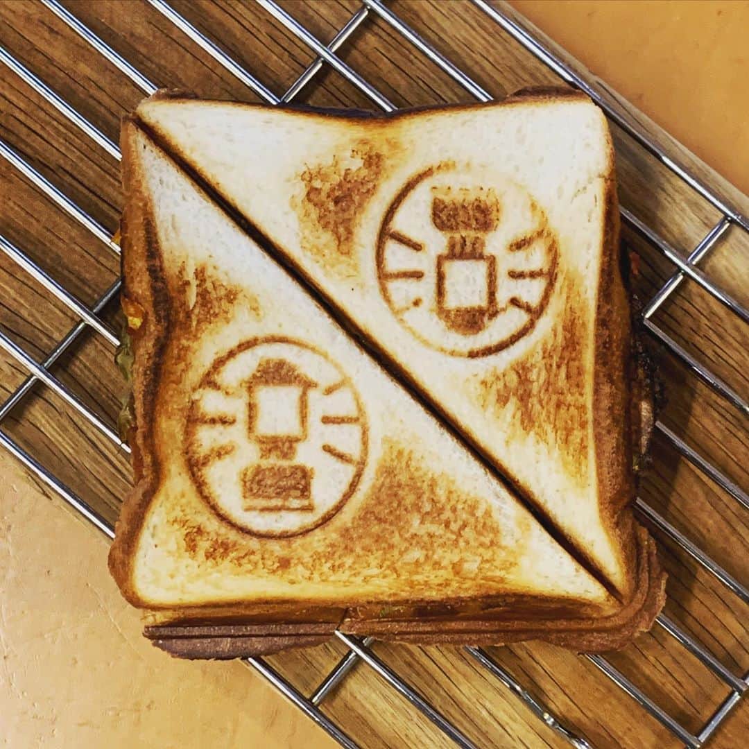 中山祐一朗のインスタグラム：「まな板に直接載せないで、網の上でさましてからラップで包めばベシャッとならないらしい、なるほど！ 焼き加減は弱め中火で2分×2だけど #最終的には焦げたにおいをくんくんして確かめつつ仕上げます #ホットサンド #たまご　#レタス　#ハム　#チェダーチーズ　#バター　#マヨネーズ  #ケチャップ #コールマン　 #役者飯 #猫ニャキャヤマ飯  #レシピ帳　は台本の　#裏紙」