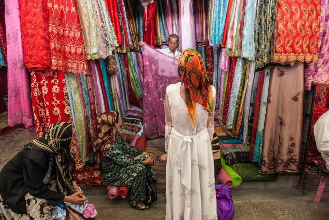 National Geographic Travelさんのインスタグラム写真 - (National Geographic TravelInstagram)「Photo by @francescolastrucci  Uygur women buy silk for a wedding at the market in Kashgar, Xinjiang Province, China. Kashgar’s Sunday Bazaar is arguably the biggest market in Central Asia, with a history stretching back 2,000 years to the ancient Silk Road times. Vendors sell food, spices, carpets, fabrics, livestock, and almost anything you can think of.  Located in the remote desert of the westernmost corner of China, close to the borders of Pakistan, Afghanistan, Kyrgyzstan, and Tajikistan, Kashgar has always been a major convergence point for different cultures. Today it is predominantly populated by Uygurs. Follow me @francescolastrucci for more places, daily life, and stories around the world. #silkroad #dailylife #market」9月14日 1時06分 - natgeotravel