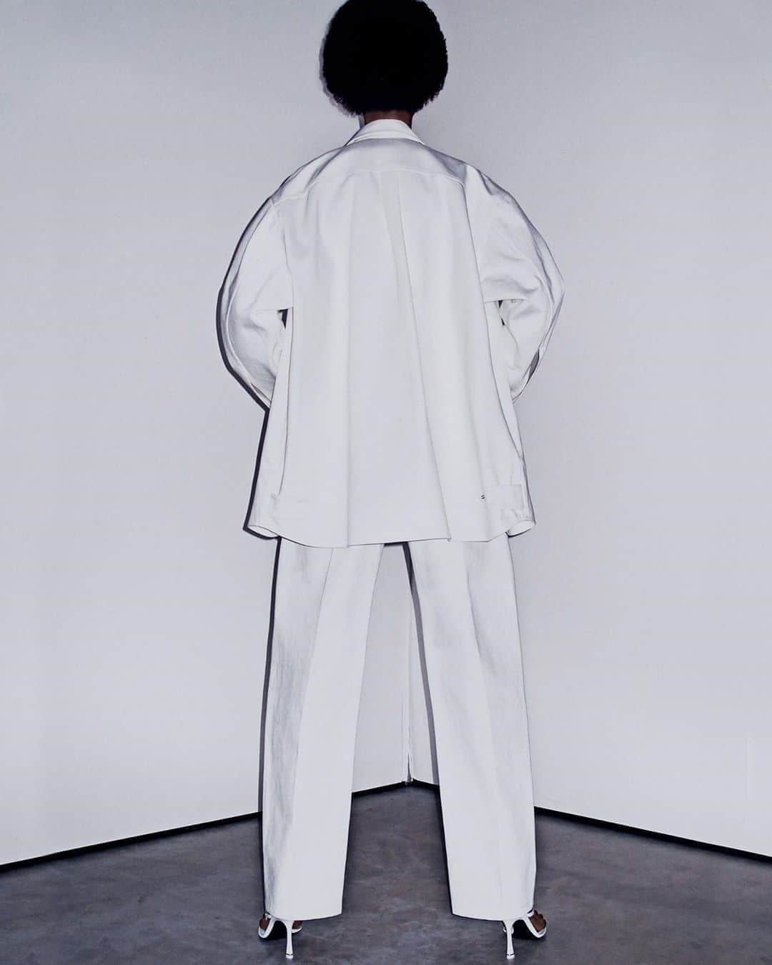 アレキサンダー・ワンのインスタグラム：「Back at it again with the white denim. -  OVERSIZED DENIM SHIRT JACKET WITH CHEST POCKET.  RAW DENIM PLEATED BOW-LEG TROUSER WITH MATTE LOGO BUTTONS.  IVY THONG SANDAL WITH DIAMANTÉ LOGO HARDWARE.  DENIM AS TAILORING SHOT TO SHOP BY STEVEN KLEIN.」