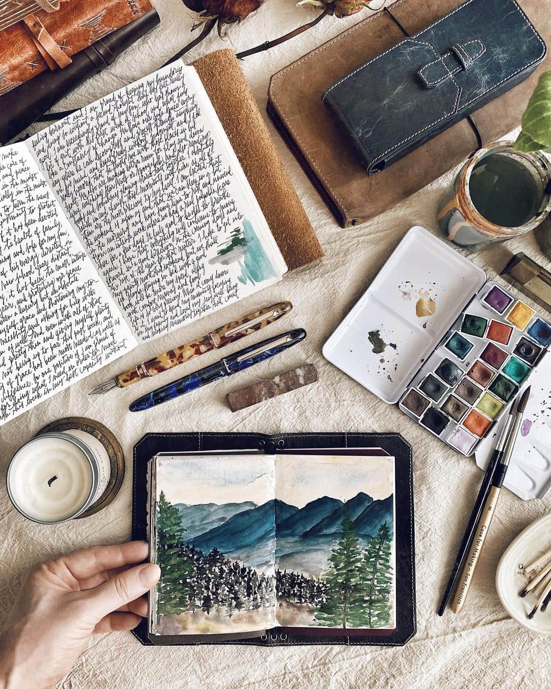 Catharine Mi-Sookさんのインスタグラム写真 - (Catharine Mi-SookInstagram)「Savouring the tiny bits of time where I can write and paint. Life brings unexpected rhythms, a theme this year, and so we adjust and attune ourselves accordingly. I’ve been holding my VN Pocket close lately as it’s the perfect size for the little bursts of creativity and musings. Today I painted this simple landscape and it was wonderful to be able to slow down, even if just for a few minutes here and there. I hope each of you are finding pockets of rest and refuel throughout your days too with silver linings and goodness laced in all the details. ✨ . . . Vagabond Pocket in NWF Dark Brown co-designed by @franklinchristoph & myself — link in bio. . Watercolors @caseformaking. Estie Fountain Pens @esterbrook_official. Leather Journal @quillandarrow. Penvelope Three Case in NWF Dark Denim @franklinchristoph. . . . #journaling #dailyjournal #vagabondpocket #franklinchristoph #vagabondnotebook #caseformaking #handmadewatercolors #abmcrafty #esterbrook #esterbrookpens #esterbrookestie #fountainpens #watercolorlandscape #watercolours #fountainpenaddict #stationerylove #travelersnotebook #flatlaystyle #passporttravelersnotebook #thedailywriting #penmanship #journalinspiration #journallove #artjournalpages #artjournaling」9月17日 4時02分 - catharinemisook