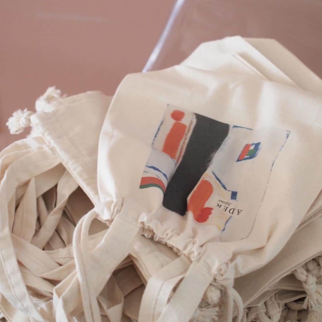 のインスタグラム：「@ader_official のエコバッグ、 本日よりオープンしたアトリエショップatelierWのオープン記念に作ってみました。  おきづきかしら、 こちらオットがこの夏描いたペイントをプリントしたものです。 気に入ったので使わせてもらいました👨‍🎨  巾着型に絞れる形で便利なこちら、ちょっとしたお出かけのお供にどうぞ。 オンラインショップでも発売してますが、大好評の様子です。 #aderbijoux #ecobag #canvasbag #エコバッグ #アデルビジュー」
