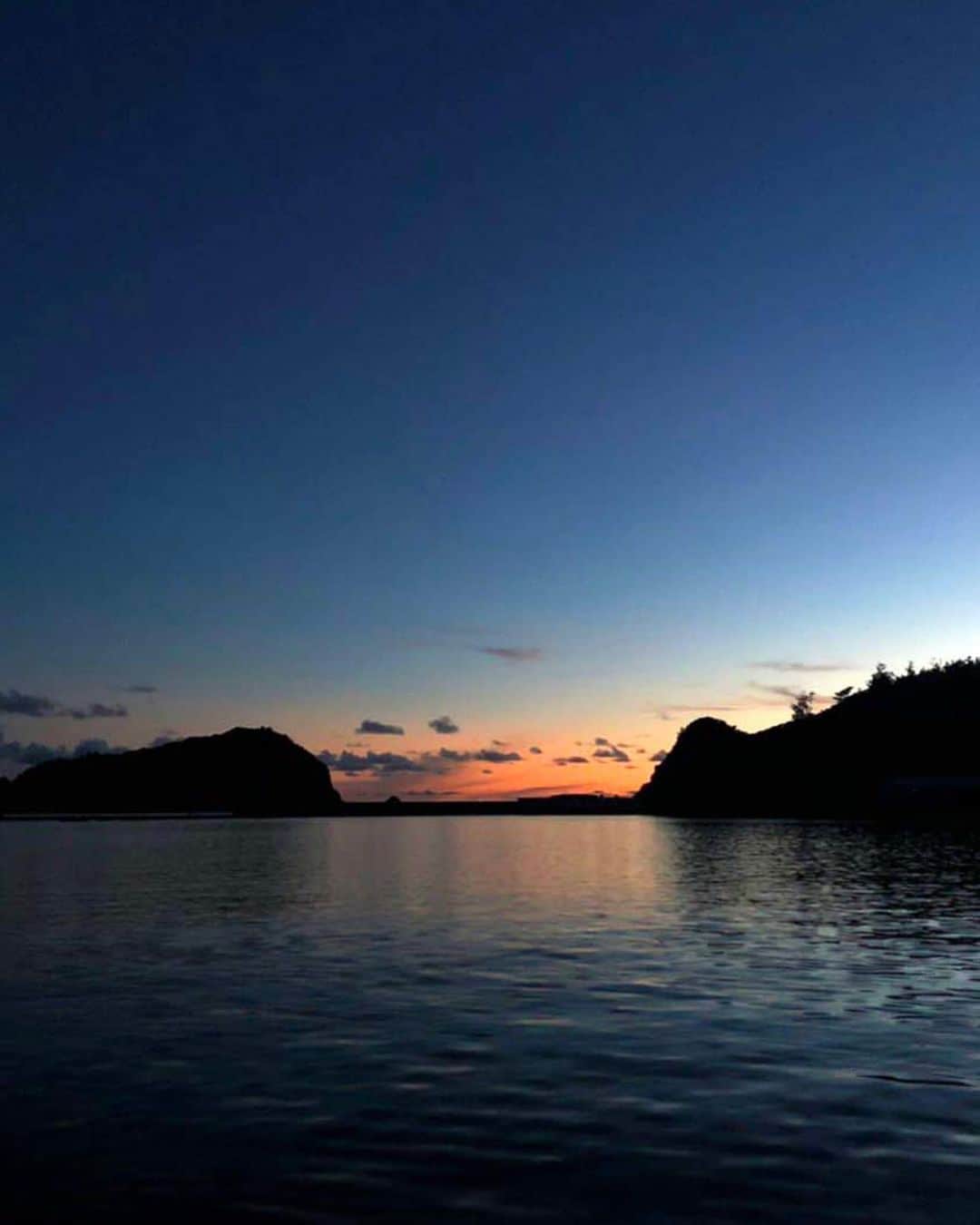 のインスタグラム：「昨日の青灯台からの夕焼け。ツルツルの穏やかな海と紺色に変わっていく空のふもとで耳を澄ましてみると、かすかにドルチェ&ガッ◯ーナの香りがしてきそうな気がしました…… . #小笠原 #小笠原諸島 #父島 #ogasawara #boninisland #南の島 #青い空と海 #島暮らし #islandlife #blueocean #サーフィン #surfstyle #世界自然遺産 #世界遺産 #worldheritage #旅が好き #lovetravel #離島 #離島暮らし #tokyo #japan #ig_japan #旅行好きな人と繋がりたい #ダレカニミセタイケシキ #夕日 #夕陽 #sunset #guiter #ギター #夕陽が綺麗」