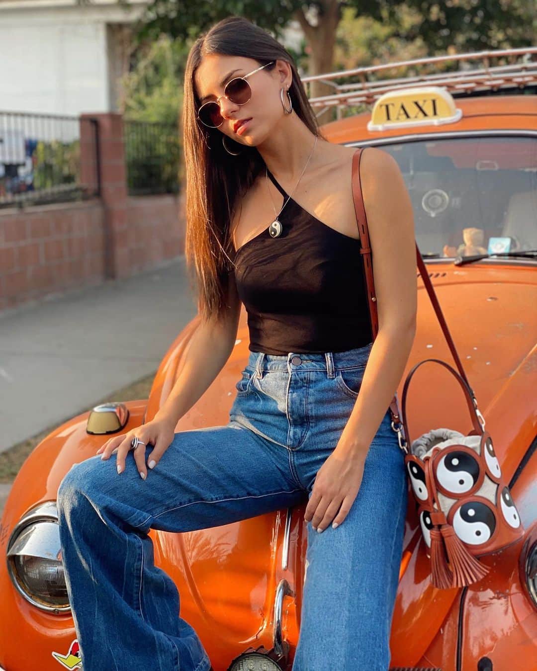 ヴィクトリア・ジャスティスのインスタグラム：「Filmed something fun yesterday. Until I can share that, here’s a pic of me in front of this sick VW bug. Lots of love to you all. 🙏🏼🤍🖤 Also, my necklace matches my bag. Just sayin’. It’s the simple things in life 😊」