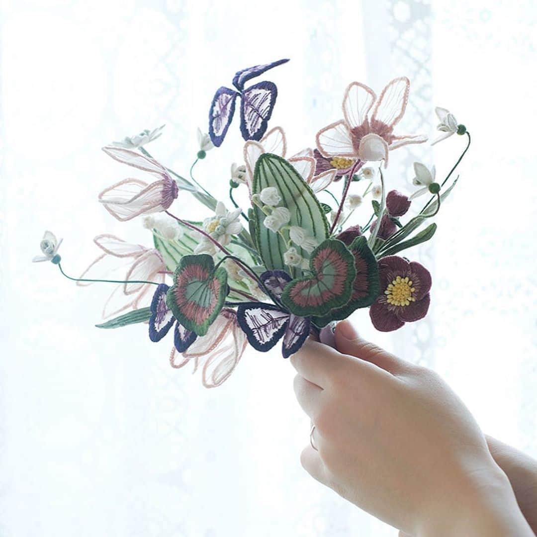 手紙社さんのインスタグラム写真 - (手紙社Instagram)「【ayumi刺繍展『Synchronicity』展示会でしかご覧になれない作品もあります】 4連休、みなさんはどんな風にお過ごしでしょうか？　手紙舎 2nd STORYでは、ayumi刺繍展『Synchronicity』を開催中です。  今回の展示では、ayumiさん自身が初めて作った「展示品」もご覧いただけます。 ayumiさんがご友人のフローリストと「温かな思いやりの心を見直そう」という思いを込めて花々を選んだそう。 それぞれの花の花言葉も楽しんでいただきたい一品です。 　・クリスマスローズ：不安を和らげる (Calm my anxiety) 　・スノードロップ： 新たなはじまり (New beginnings) 　・ピンクシクラメン：希望 (Hope) 　・紫シャムロック：悲しみと向き合い、喜びを知る(Joy in the face of sorrow) 　・すずらん：幸福が戻る (Return of happiness) 　・ゲラニウム：慰め (Comfort) 　・エーデルワイス：勇気 (Courage)  また、展示品のドレスの裾には、ayumiさんが刺繍で「お直し」した様子もご覧いただけます。 アンティークのドレスに施された真っ白な刺繍。こんな風に自然に、そして美しい補修があるのかと驚かされます。 柴崎にお越しになる方は、ぜひ見てみてくださいね。 （トルソの裏側、裾の近くとなります）  もちろん、その場でお求めいただける作品もたくさんございますよ。 ここにしかない展示空間をぜひ楽しんでいただけたらと思います。  ◎個展について @tegamisha_exhibition プロフィールリンクからも詳細をご覧いただけますよ  #手紙社 #手紙舎 #手紙舎2ndSTORY #tegamisha #個展 #刺繍 #ooayumimoo #embroidery #刺繍展 #wedding #手紙舎の個展 #アクセサリーは手紙社オンラインショップでもお求めいただけます」9月20日 11時16分 - tegamisha