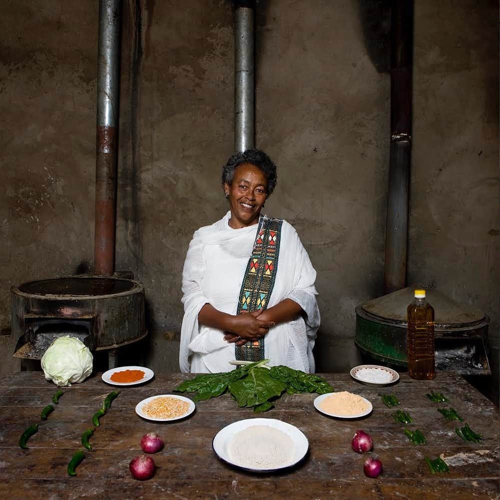 thephotosocietyさんのインスタグラム写真 - (thephotosocietyInstagram)「Photos by @gabrielegalimbertiphoto - From my project GRANDMA'S RECIPES. Bisrat Melake, 60 - Addis Ababa, Ethiopia / ENJERA WITH CHURRY AND VEGETABLES- Difficulty: medium - Time: 3 days (if you need to prepare the enjera), less than 2 hours if the enjera is already ready - Ingredients: 1 savoy, 10 sweet green chillies and 25 string beans, red chilli powder, 4 onions, oil, salt, pepper, cauliflower leaves, a plate of Mitin Shuro (yellow dried peas powder), a plate of split peas, yeast, Teff flour (cereal from Ethiopia) / To prepare this dish you need to cook different ingredients separately. It is the product of various recipes. The Enjara, whose preparation takes 3 days, is the first thing to make: ENJARA: Mix 1 kilo of teff flour and 1 spoon of yeast with some water until you obtain a smooth and dense dough - let it ferment for 3 days - now the dough should be much softer than when you prepared it 3 days before. Add water until it becomes cream-like. Use it in the same way as when you make crepes. If you have the possibility to use an Ethiopian oven in ceramic (like the ones at her back in the photo), do use it! / CHURRY (in the centre of the photo): Stir fry 3 chopped onions and 10 chopped sweet chillies in some oil for a few minutes. Add 3 glasses of water and let it cook for about ten minutes. Then, add the split peas and the plate of Mitin Shuro. Mix well, cover with a lid and cook on a low heat for about 30 minutes / CAULIFLOWER LEAVES (the dark green vegetables on the sides of the photo): Boil some cauliflower leaves in water. Drain and chop them and fry them in a pan with some oil, onion and salt / LIQUID CHURRY (the small orange spots in the photo): Fry lightly half an onion and a pinch of hot chili powder in some oil. Add 200 grams of Mitin Shuro and two glasses of water. Cook for 20 minutes / STRING BEANS AND SAVOY SALAD: Slice the savoy into stripes and chop the beans. Boil everything together in some water to suit your taste. Drain the vegetables and put them in a pan with oil and chili to sauté them for about ten minutes / Now that all the ingredients are ready, you can place them in the dish as it is shown in the photo and serve it. #grandma」9月23日 1時35分 - thephotosociety