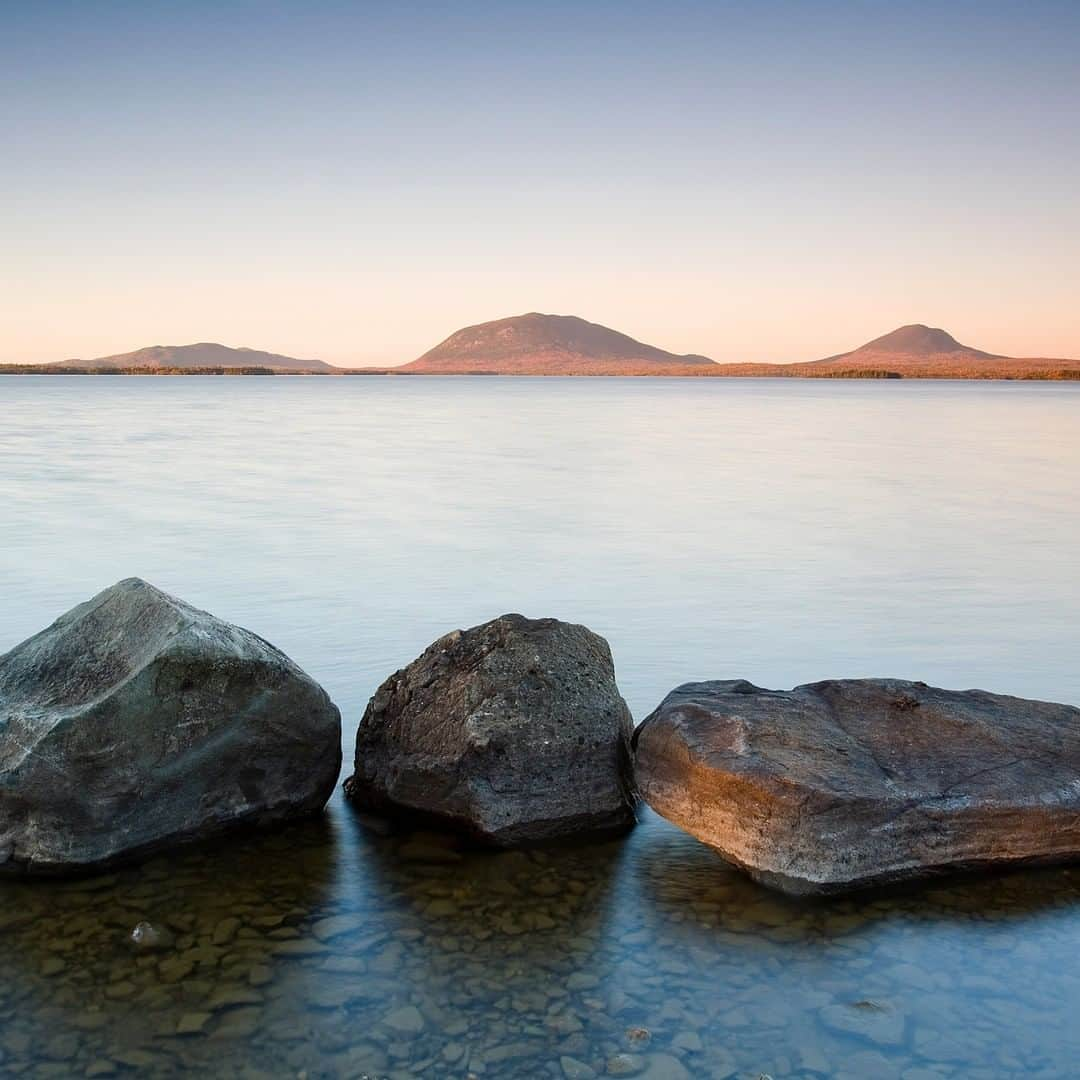 Discoveryさんのインスタグラム写真 - (DiscoveryInstagram)「“I've actually photographed this exact same spot in Greenville, Maine, more than once, and years apart. Of the two compositions, which are almost identical, this one is by far my favorite. The differences are subtle, but the defining factor that made me choose this particular frame is the way the autumn colors on the distant mountains pop out with the last bit of light of the day. I think I've always been attracted to this spot because of the symmetry of the three rocks and the three hills in the distance.” (Click in bio for full gallery)  Photo + caption by @ianshivephoto 📸  #NatureinFocus #FallEquinox #autumn #calmness #tranquility #nature #views #serenity #water」9月23日 2時30分 - discovery