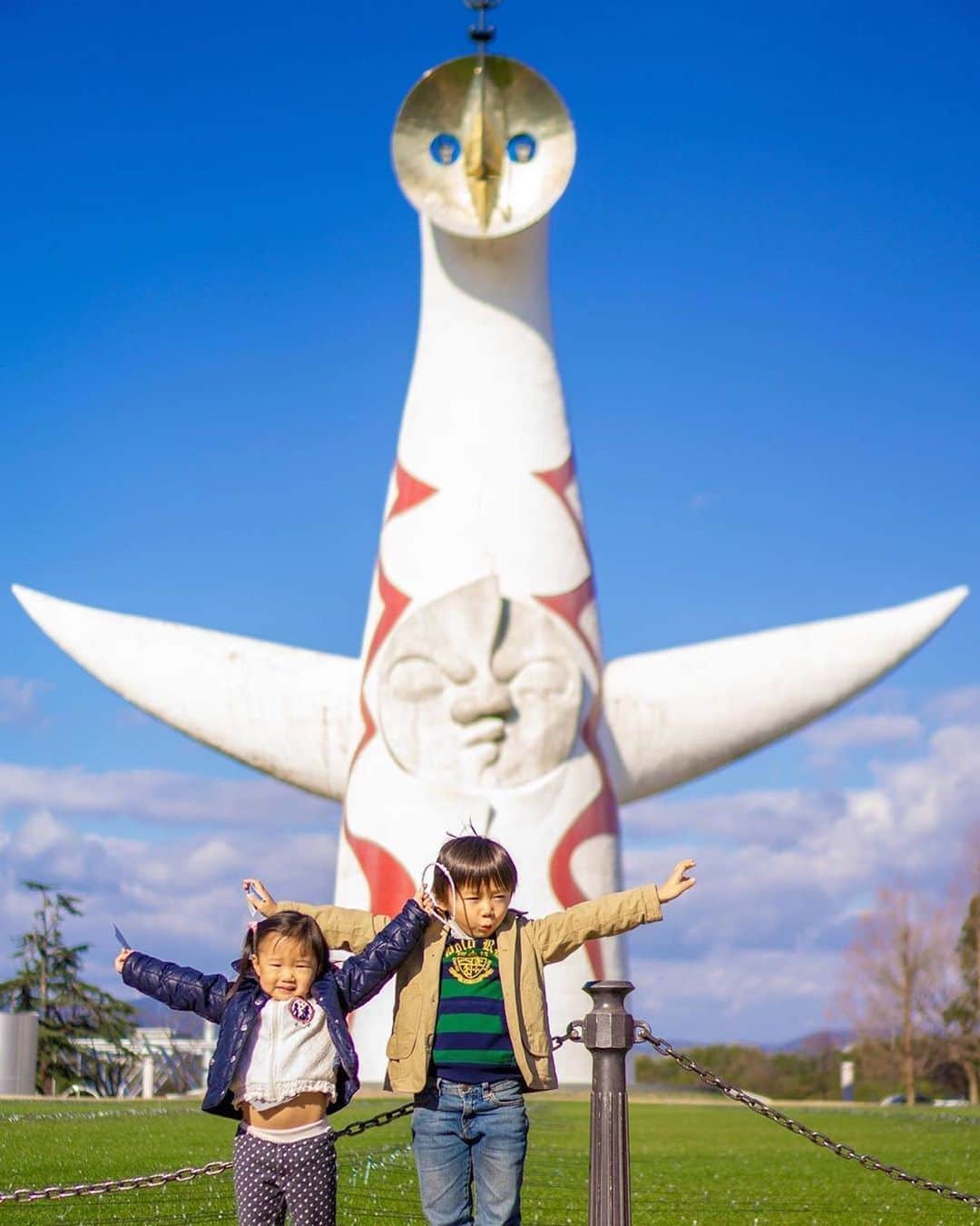 ピーチ・アビエーションのインスタグラム：「腕をのばして、おんなじポーズでパシャリ！ 大阪万博公園のエネルギッシュなシンボル #太陽の塔 ☀には実は顔が３つあることを、ご存知ですか？ . ひとつ「現在」を象徴した中央の顔、 ふたつ「未来」を象徴した金色に輝く顔、 みっつ「過去」を表す顔が背面にあるんです😳 ぐるりと一周して色んな表情を見られます✨ . 予約をして塔の内部に入ることもできます。 チェックしてみて下さいね♪👀 . . . . . . . . . . . . . . . . . . . . . . . . . . . . . . . . . . . . ▶Photo by @pokaponta525 OOKINI!! ▶Place： #大阪府 #吹田市 . . . . . . . . . . . . . . . . . . . . . . . . . . . . . . . . . . . . Peachでは各就航地で撮影された皆さまのお写真をInstagramでご紹介させていただいています。 #fly_peach をつけて投稿してください✨ . #万博記念公園 #万博公園 #大阪旅行 #大阪観光 #関西旅行 #日帰り旅行 #ぶらり旅 #家族旅行 #観光名所 #日本の景色 #日本の風景 #家族でお出かけ #お出かけスポット #アート巡り #osaka #osakatrip #japantrip #osakatravel #japan_of_insta  #japantravelphoto #nipponpic #look_japan」