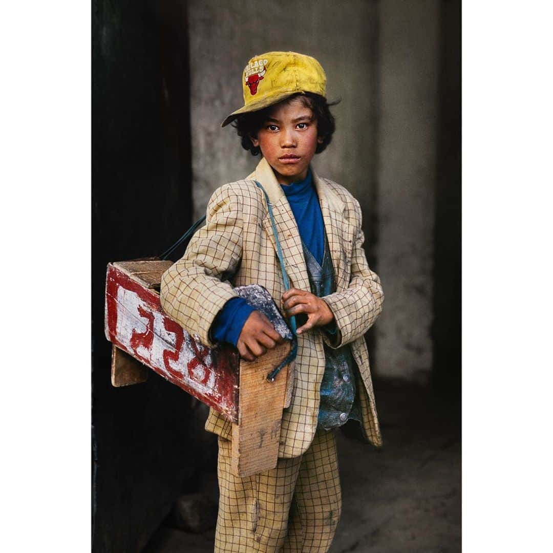 スティーブ・マカリーさんのインスタグラム写真 - (スティーブ・マカリーInstagram)「Shoeshine boy in Lhasa, Tibet. Working on the street, he pauses for a moment to see if I want more than just a photograph. The numbered box indicates that he is part of a bigger operation of vendors canvassing the city in search of customers.  #SteveMcCurry」9月26日 2時14分 - stevemccurryofficial