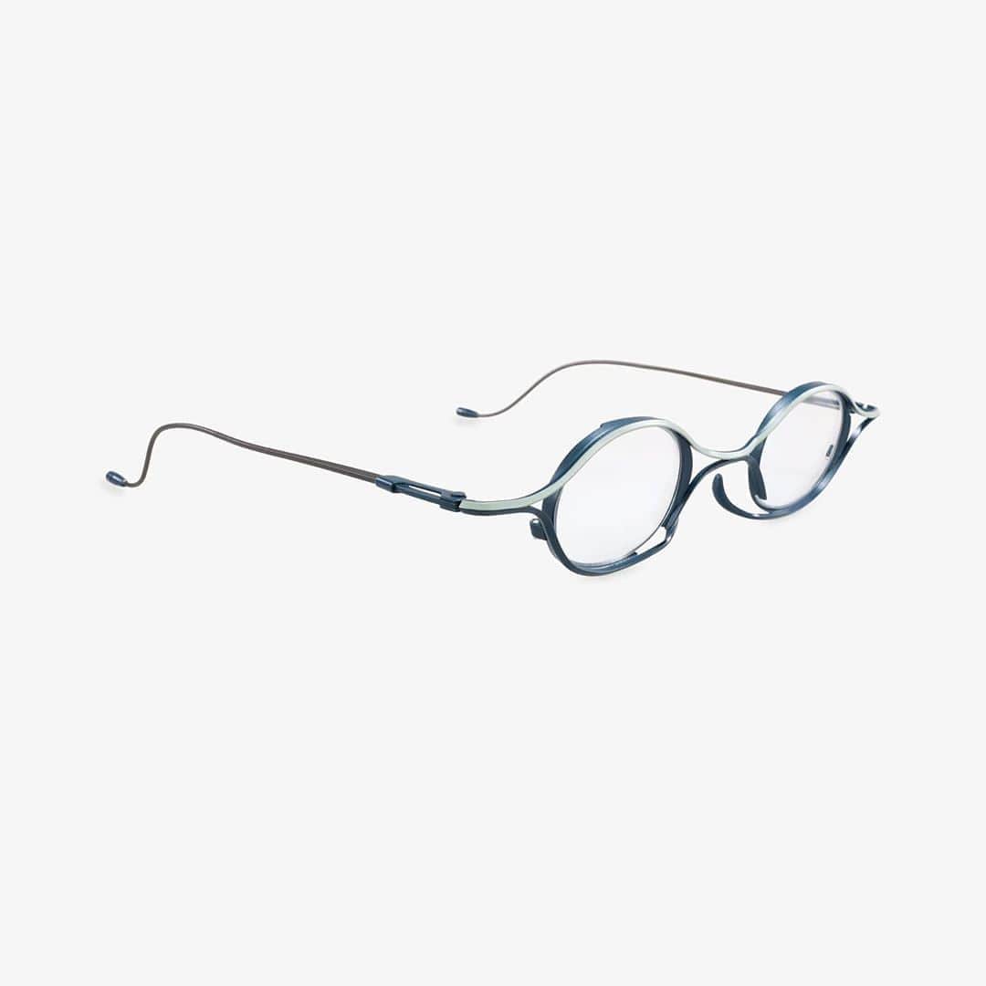 のインスタグラム：「Model no.#RG2003 nominated for Silmo d'Or. . #rigards #silmodor2020 . Less is More . Cubism’s penchant for breaking down the familiar into raw geometric shapes is celebrated in RIGARDS RG2003, a finely wrought style that calls to mind simplified human eyes, as often depicted in iconic Cubist portraits. . The frame’s artful construction from slender angled steel bars is the start of its appeal. Bound together by tension and equilibrium, the bars curve sinuously along an infinity path to converge into a sideways figure 8, delivering a signature play on the two eternal symbols of balance and propitiousness. . Despite its lithe spider-like grace, the frame asserts itself with a sculptural fullness brought forth by the nuances of shadows created in the gentle convex/concave undulations. . The clean aesthetic hides robust details: slightly recessed rims that enhance the perception of depth and three-dimensionality; a pair of upwardly extending bars (inspired by the notion of insect  mandibles) that functions as stealthy nose pads and creates the illusion of the frame seemingly  floating on the wearer’s face. . We designed also a detachable clip-on sun-lens (crafted using flexible beta-titanium), the perfect  addition for the brightest days. . The frame comes in 5 flattering colorways, each with a dashing hand-painted contrasting or  matching accent hue. . Modern abstract masters saw the complicated and reduced it to pared back forms, thus epitomizing  “less is more”, and that is what we have explored through RG2003.」